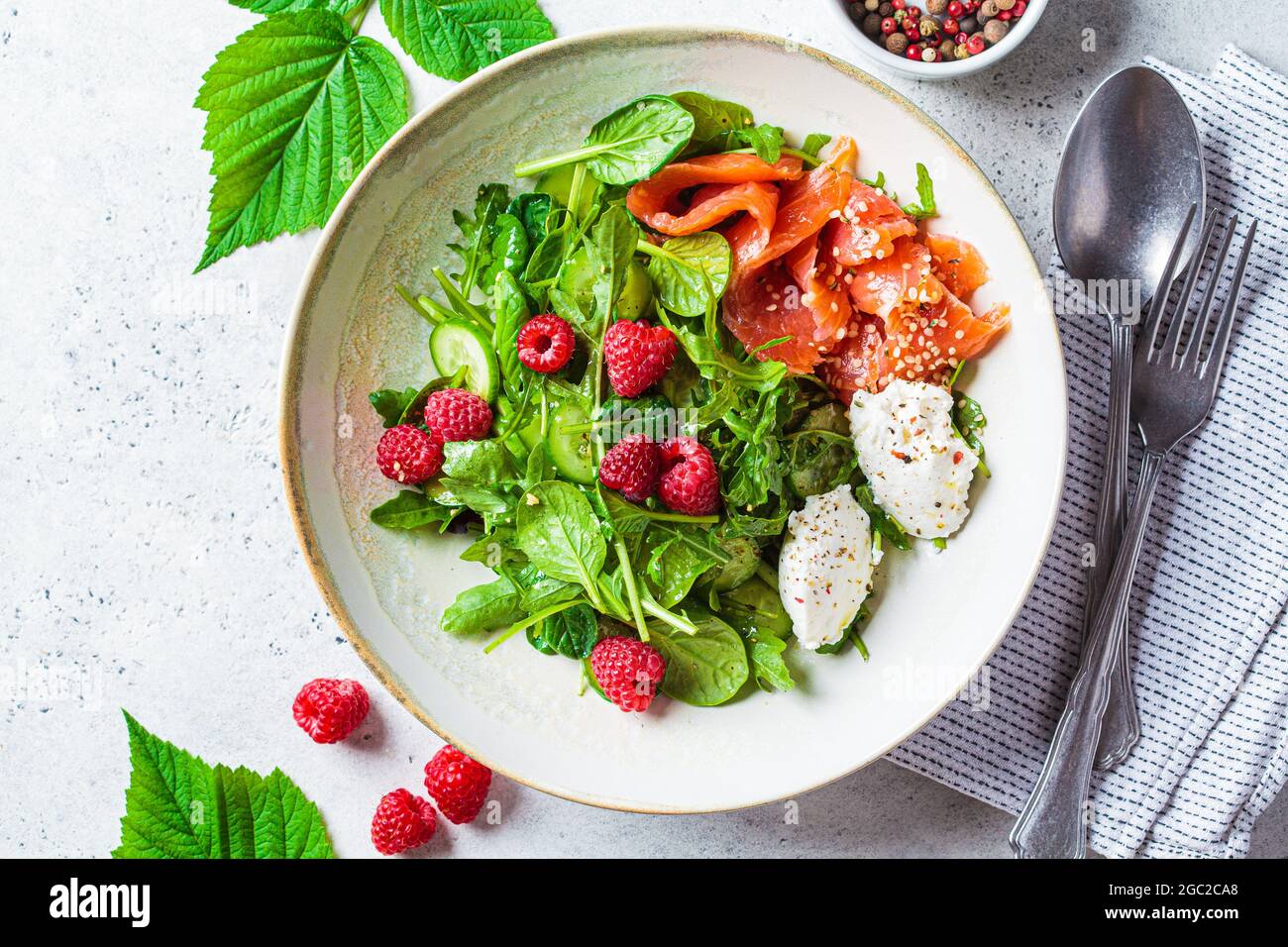 Sommersalat mit gesalzenem Lachs, Ricotta und Himbeeren, Draufsicht. Gesundes vegetarisches Lebensmittelkonzept. Stockfoto