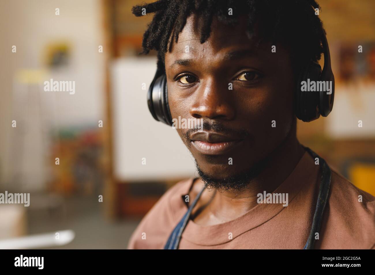 Porträt eines afroamerikanischen Malers bei der Arbeit mit Kopfhörern im Kunststudio Stockfoto