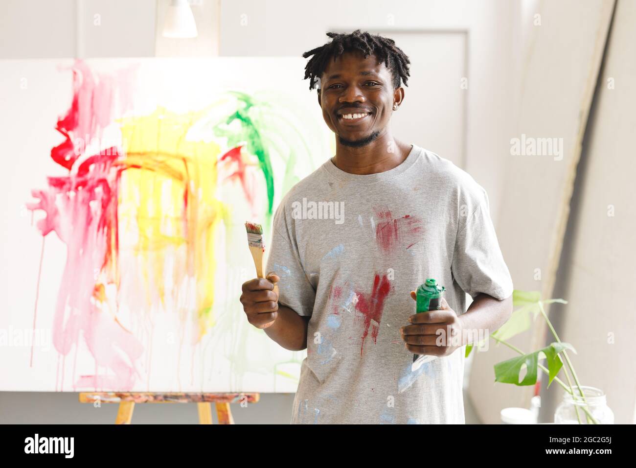 Porträt eines afroamerikanischen Malers bei der Arbeit mit Pinsel und Farbe im Kunststudio Stockfoto