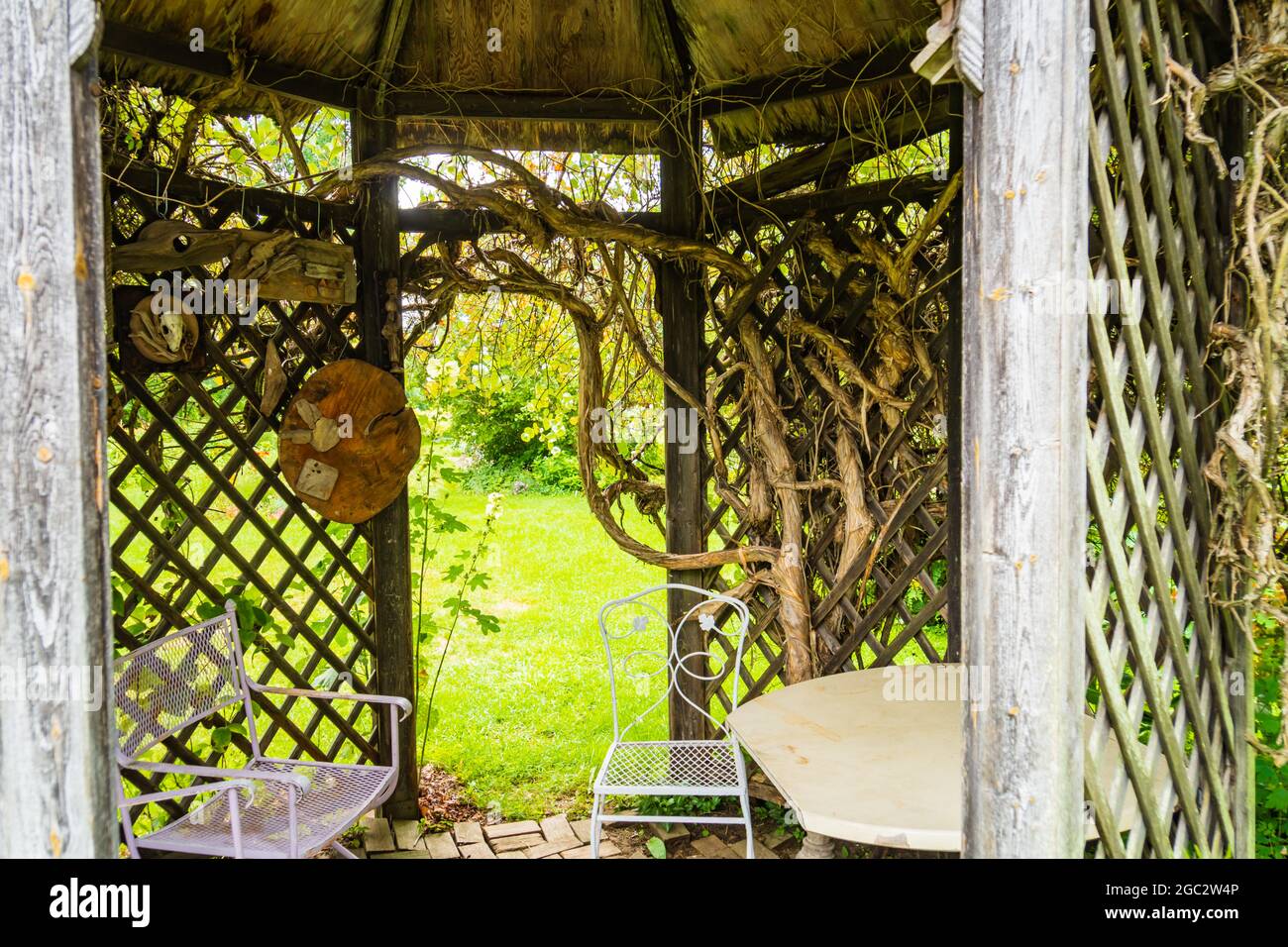 Achteckiges Holzgitter bedeckt Rückzugsort in einem Garten Stockfoto