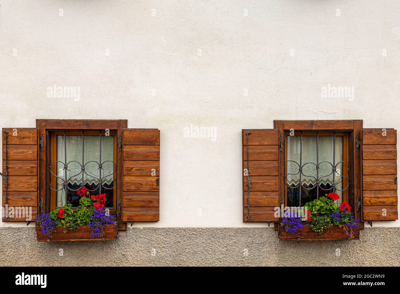 Typische alpine Hausfenster mit blühenden Pflanzen Stockfotografie - Alamy