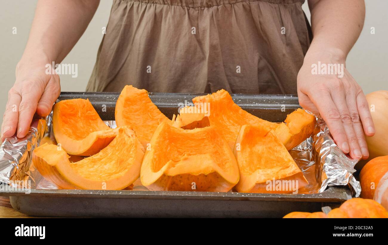 Kürbisscheiben schließen auf einer vorbereiteten Backform. Kürbis backen, Schritt für Schritt Kürbispüree Rezept, Lifestyle Stockfoto