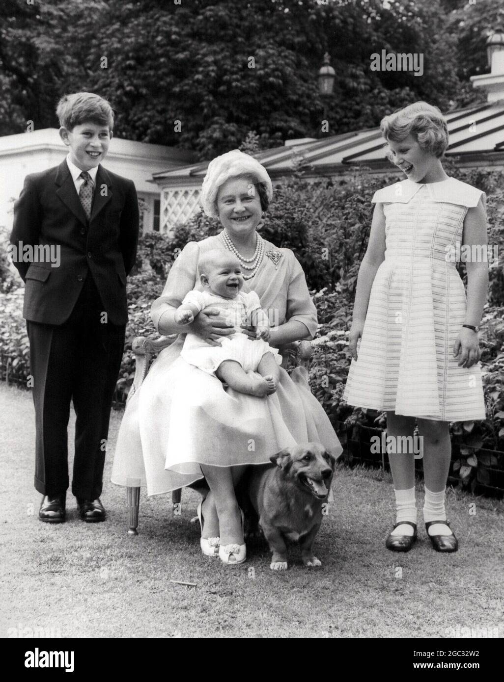 Königin Elizabeth, Königin Mutter fotografiert mit ihren Enkeln an ihrem 60. Geburtstag. Prinz Charles (links), Prinzessin Anne (rechts) und Prinz Andrew sitzen glücklich auf ihrem Knie. Garden of Clarence House - 4. August 1960 Stockfoto