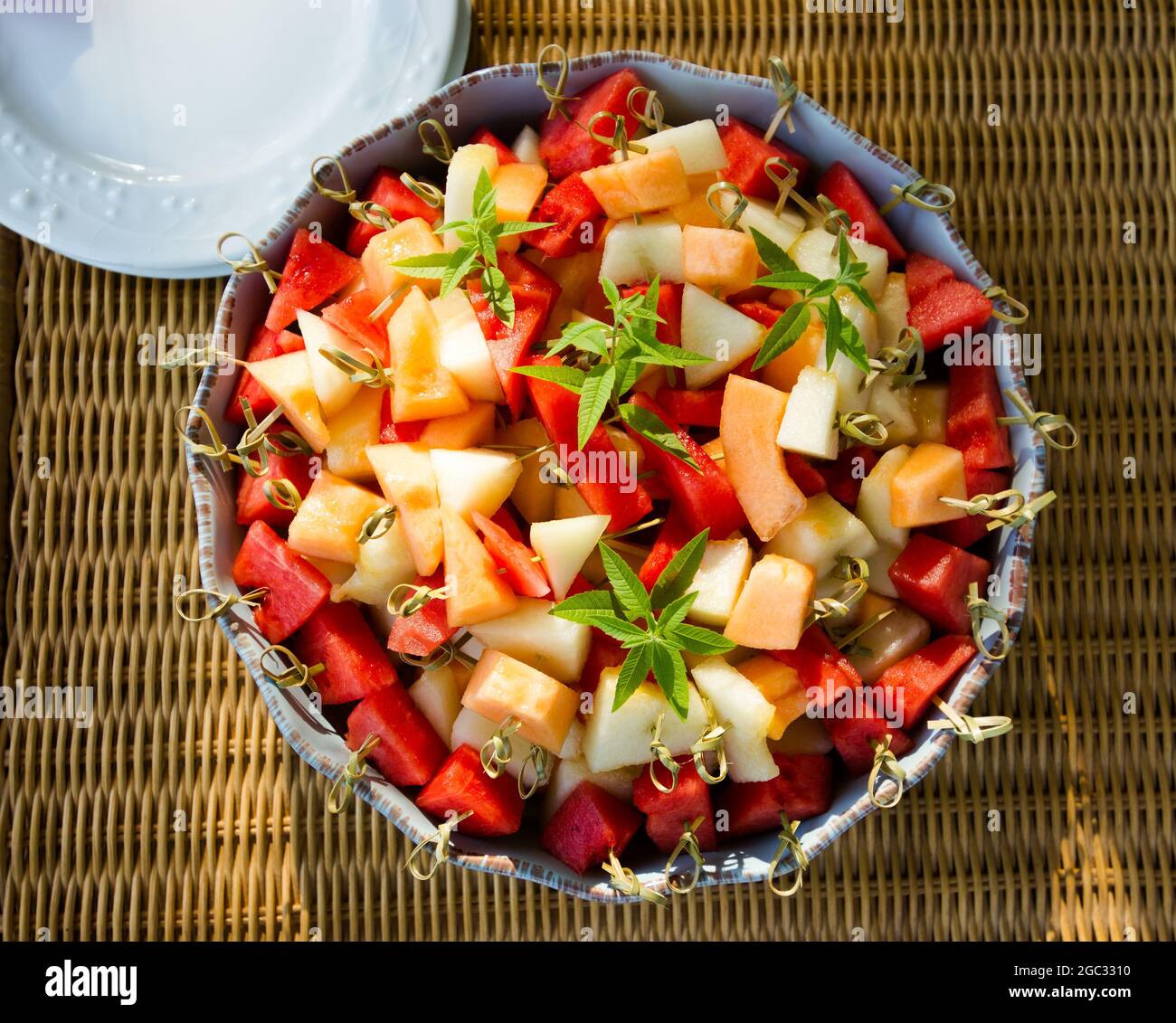 Große Schüssel mit frisch geschnittenem Obst, Melone, Wassermelone, auf Bambusstäbchen. Stockfoto