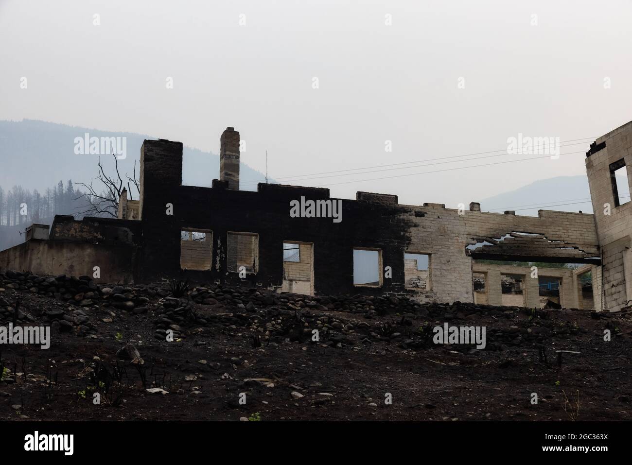 Feuer Trümmer von Häusern in einer kleinen Stadt mit Rauch am Himmel. Stockfoto