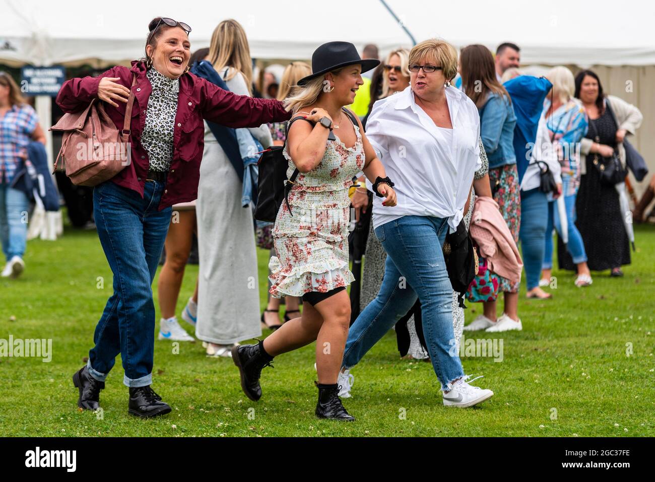 Frauen, die bei einem Konzert-Musikfestival beim Fantasia-Event im Promenade Park, Maldon, Essex, Großbritannien, an die Front kommen. Nach COVID-Einschränkungen Stockfoto