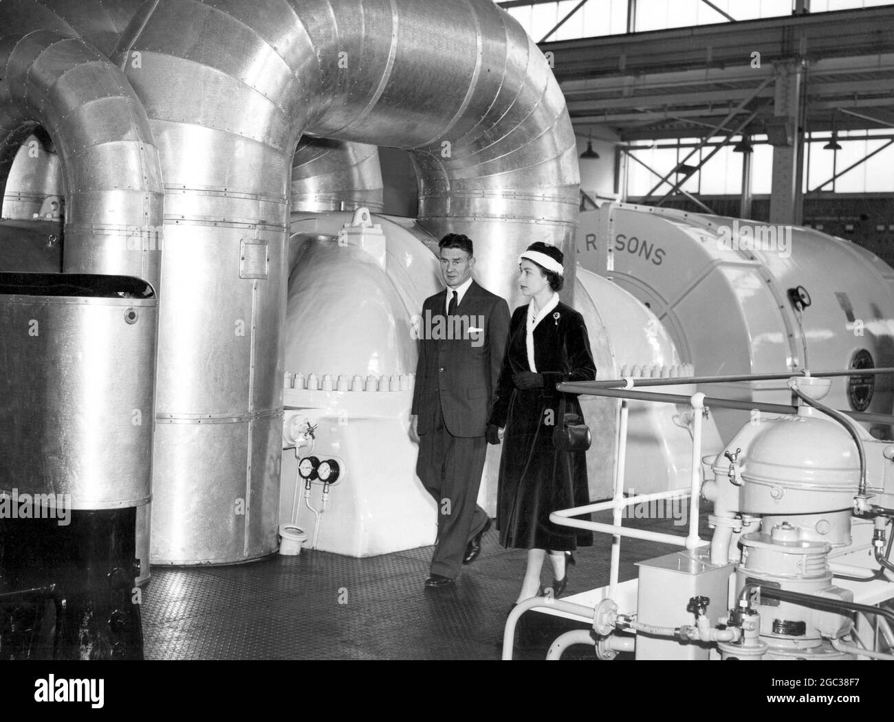 Die Queen geht in die Turbinenhalle der Calder Hall, Cumberland, ein, das weltweit erste Atomkraftwerk im Vollmaßstab, das sie am 17. Oktober 1956 offiziell eröffnete Stockfoto