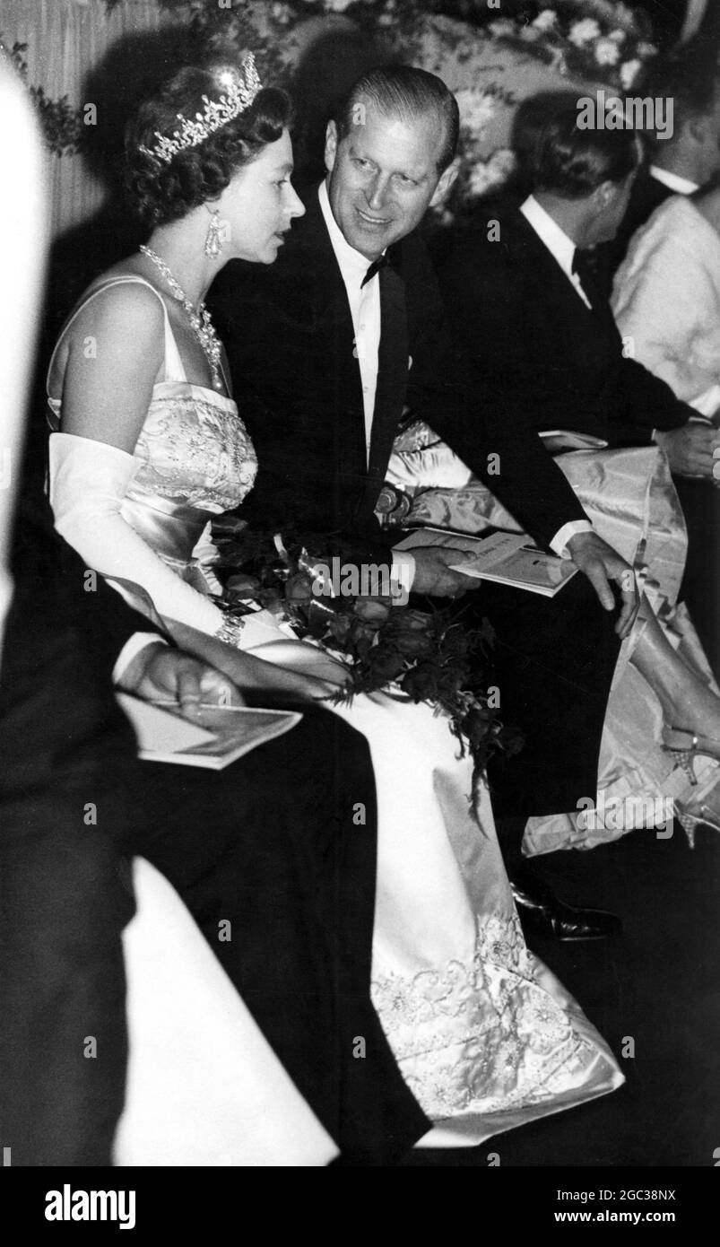 Der Herzog von Edinburgh wendet sich an die Königin Elizabeth II., die ihren Platz in der Royal Box für die Premiere des Films The Guns of Navarone am 27. April 1961 einnehmen wird Stockfoto