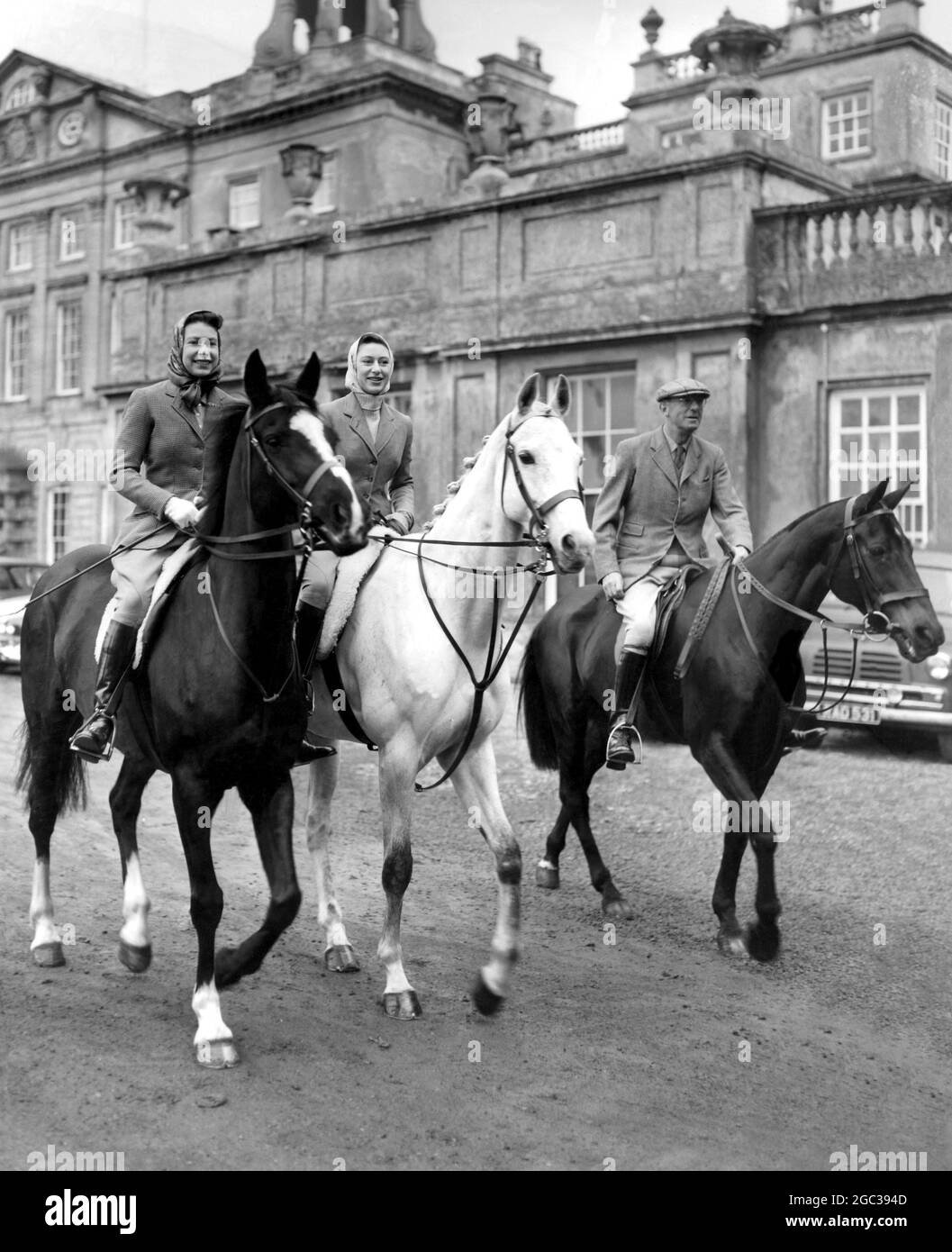 Königin Elizabeth II und Prinzessin Margaret bei den Badminton-Pferdetrials. Im Hintergrund befindet sich das Haus des Duke of Beaufort, das Badminton House, in dem die Königin und die Prinzessin während des dreitägigen internationalen Events im Badminton Park Gloucestershire am 18. April 1959 spielen Stockfoto