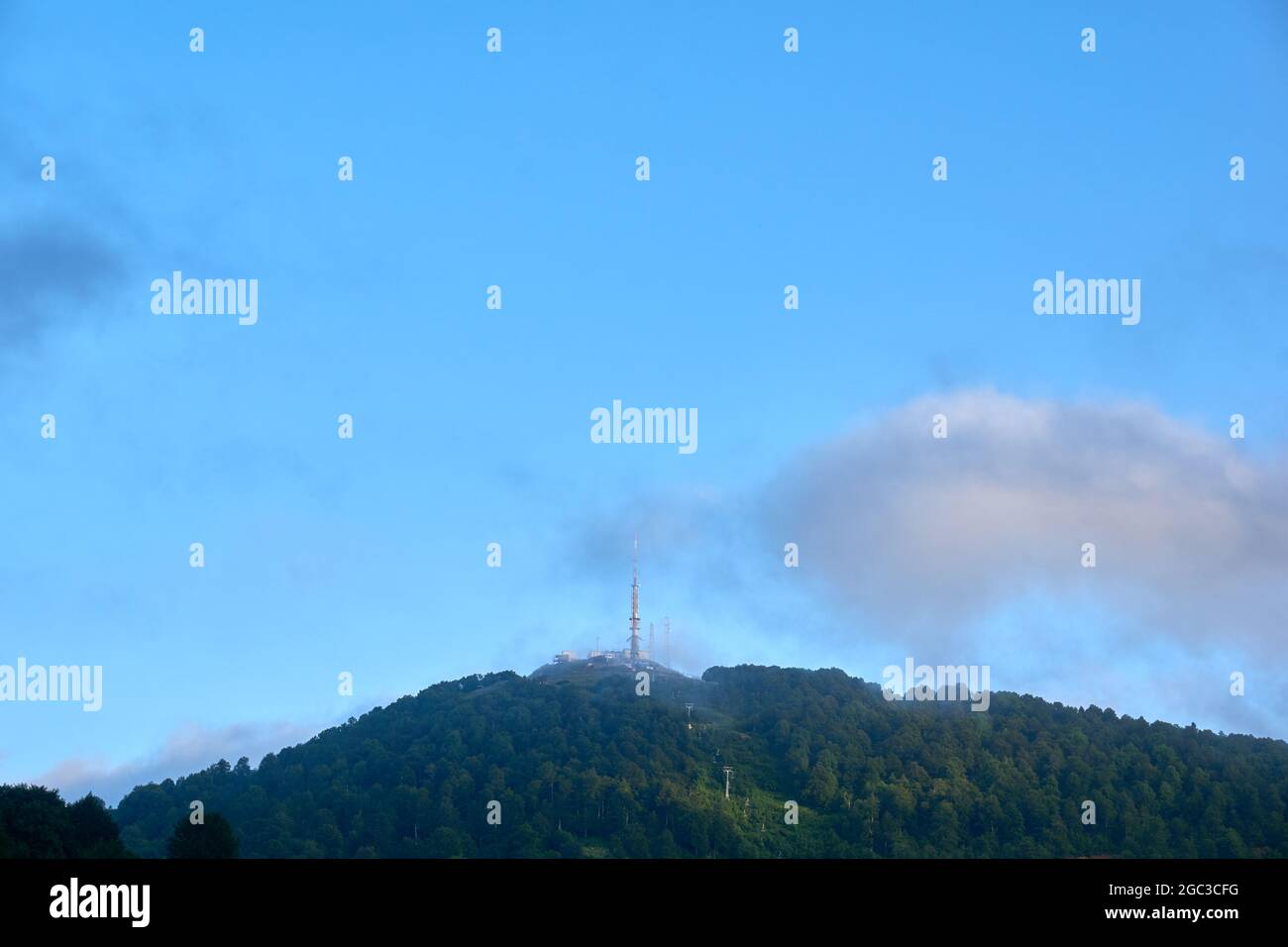 Berggipfel mit wunderschönen Wolken, Turm und Lift Stockfoto