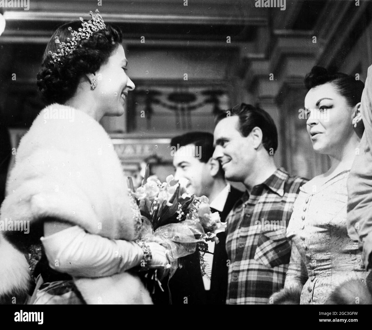 Königin Elizabeth II. Unterhielt sich mit den Stars im Theaterfoyer. Sie wird lächelnd dargestellt, als sie mit Judy Garland sprach - 19. November 1959. ©TopFoto Stockfoto