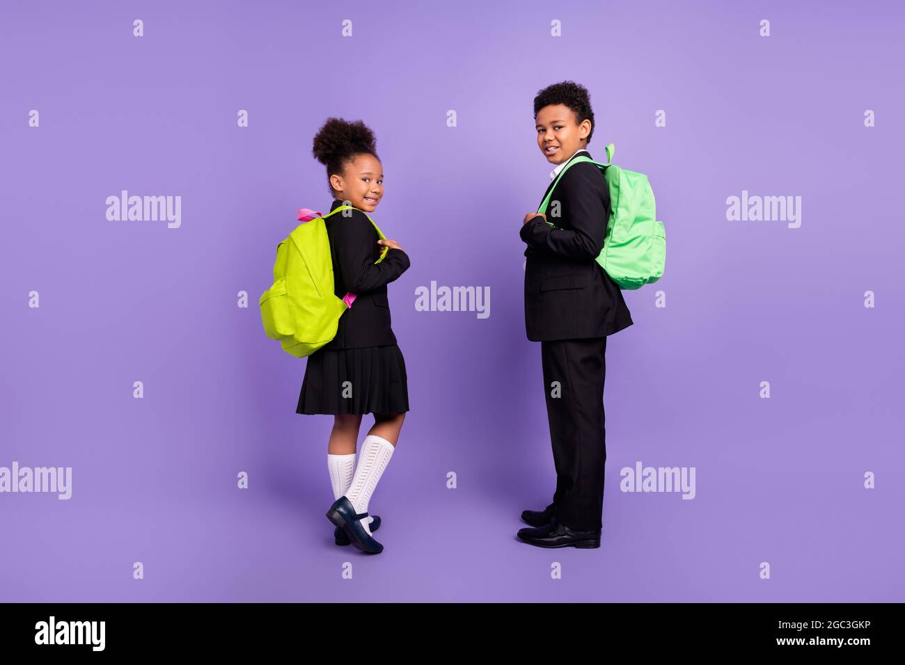 Foto von zwei afrikanischen Menschen Kinder bereiten sich auf die Schule tragen Rucksack Uniform isoliert lila Farbe Hintergrund Stockfoto
