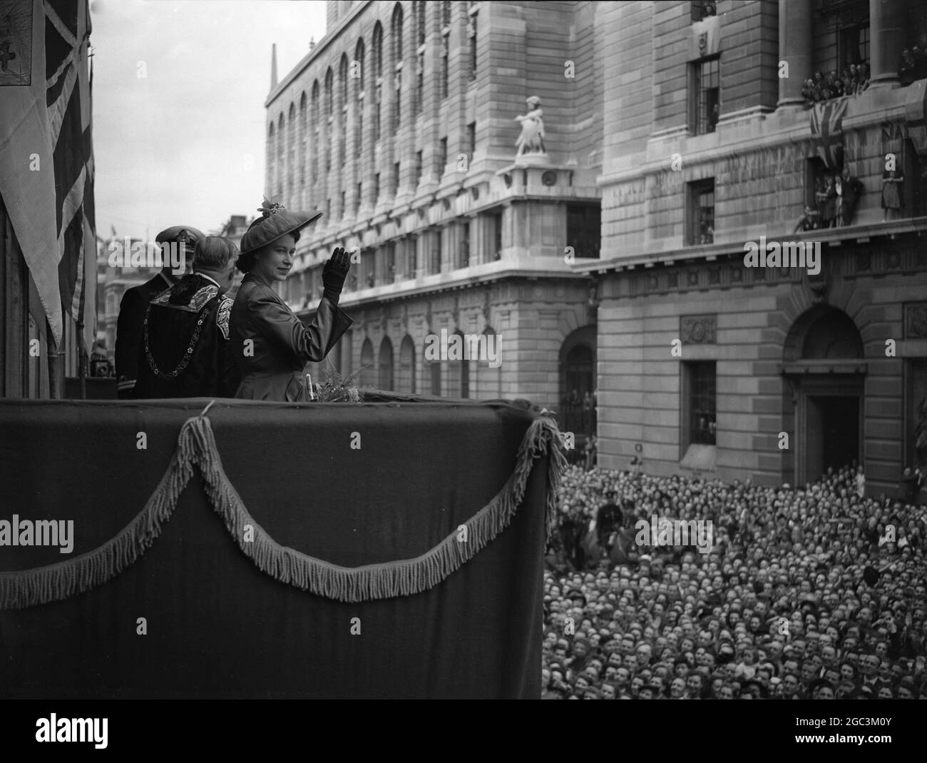 Der Herzog von Edinburgh mit Prinzessin Elizabeth fährt durch die Guildhall, um die Freiheit der City of London zu erhalten. Prinzessin Elizabeth und der Herzog von Edinburgh sahen den Jubel der Massen vom Balkon des Herrenhauses, wo sie nach der Zeremonie im Guildhall zum Mittagessen gingen, anerkennend. Juni 1948 Stockfoto