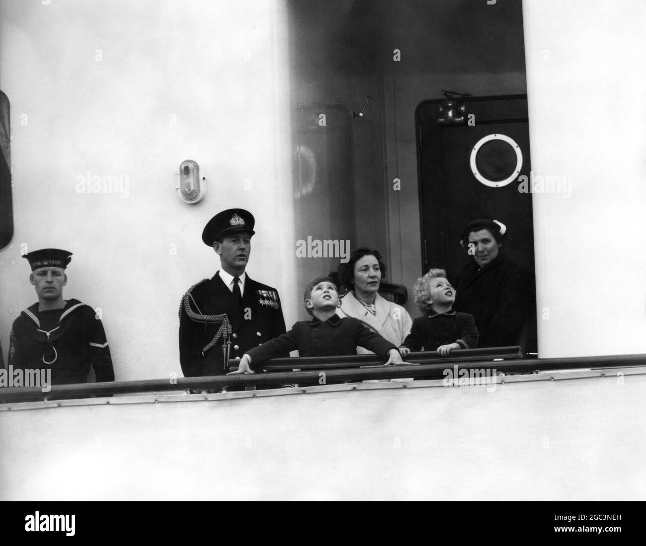 Portsmouth, England; die Augen von Prinz Charles und Prinzessin Anne blicken nach oben, als sie auf der Brücke der Royal Yacht, Britannia, die heute von hier aus segelte, stehen. Die beiden Kinder, die diese Ufer zum ersten Mal verließen, werden nach Tobruk gebracht, wo sie mit der Königin wiedervereint werden. 14. April 1954 Stockfoto