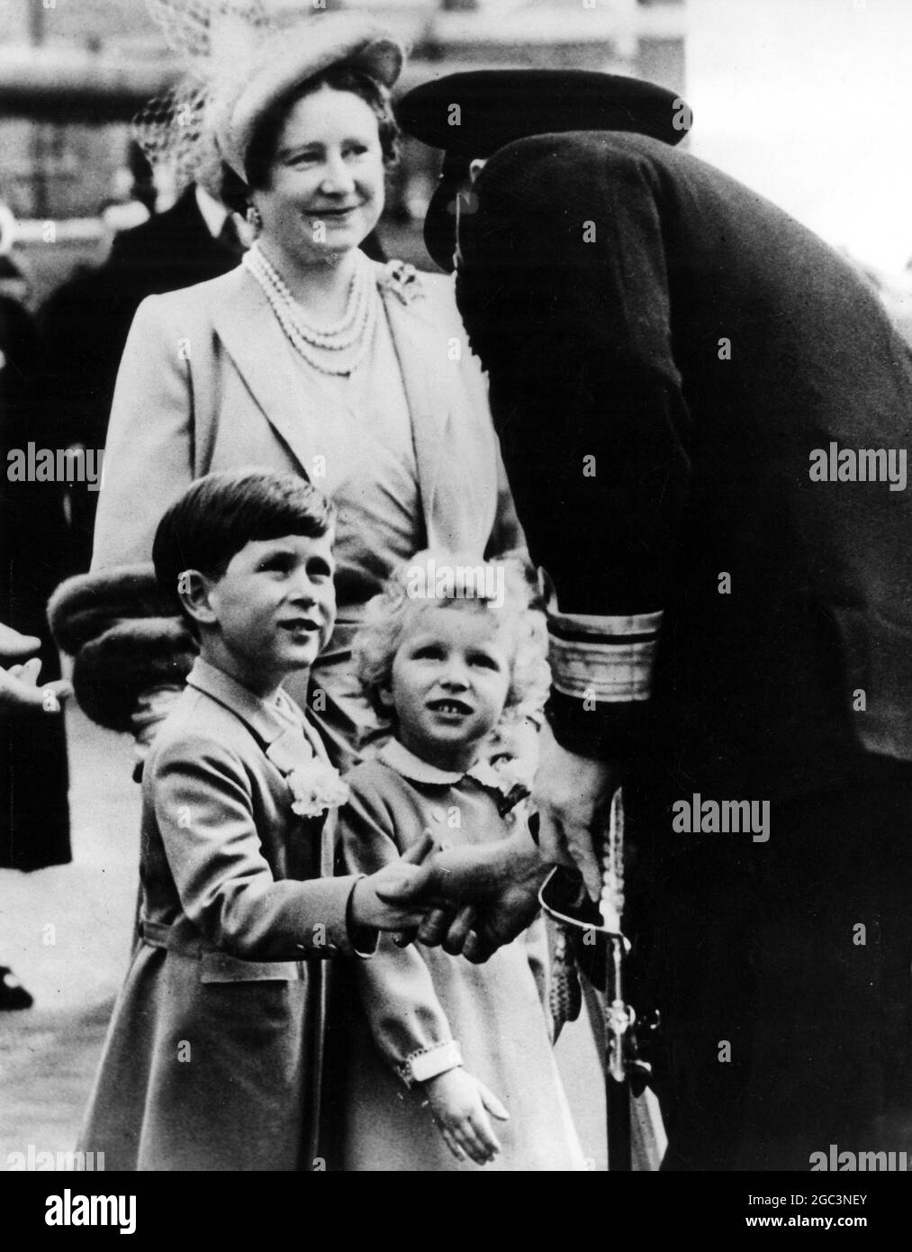 Prinz Charles schüttelt sich die Hände mit dem Konteradmiral A G V Hubbeck, Admiral Superintendent von Portsmouth Dockyard, bevor die königlichen Kinder an Bord der königlichen Yacht Britannia in Portsmouth gingen. Mit den Kindern ist die Queen Mother, die mit Prinzessin Margaret die Kinder auf ihrer Reise sah, um die Königin und den Herzog von Edinburgh in Tobruk zu treffen. 15. April 1954 Stockfoto