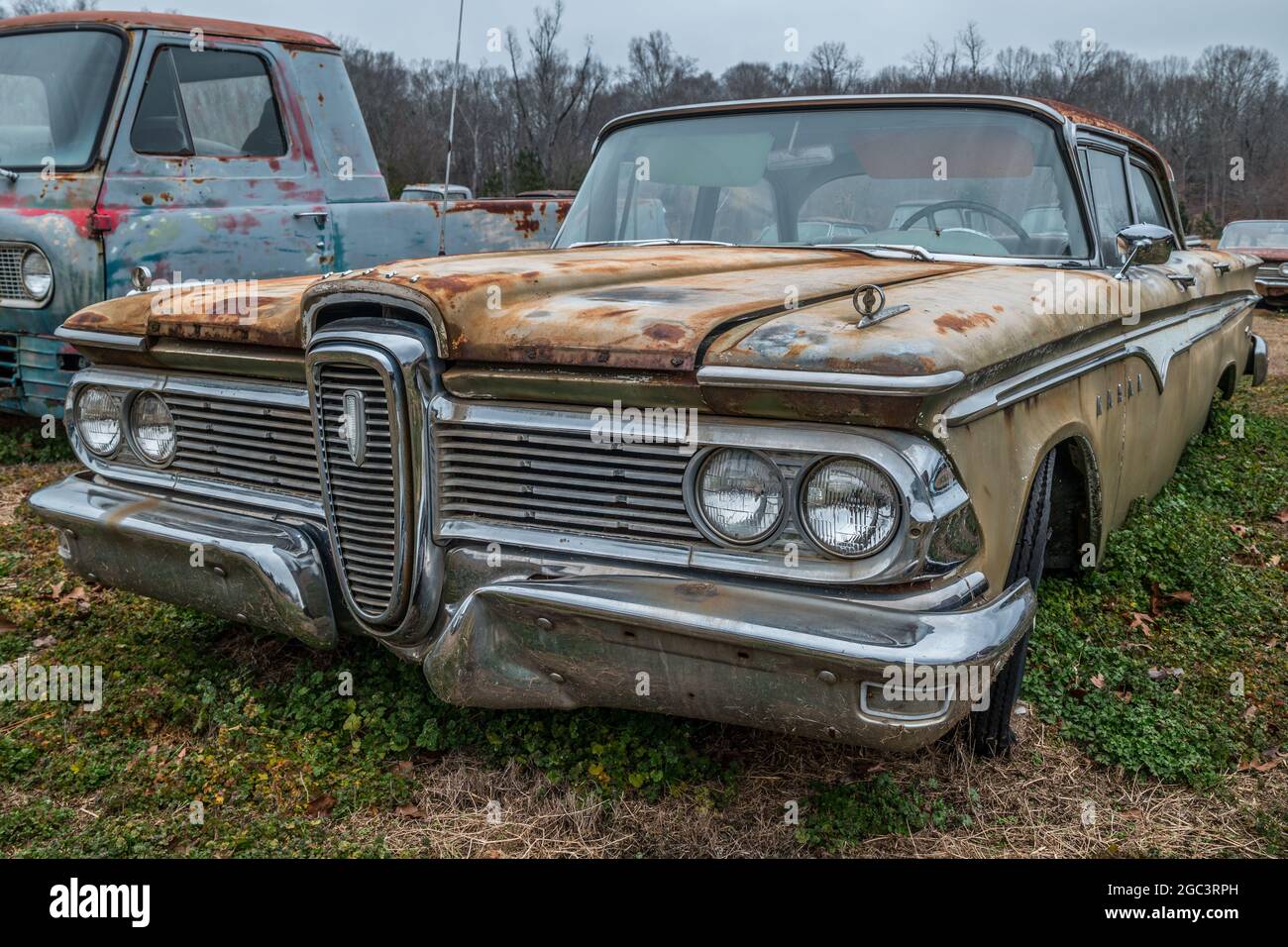 Ein vollständig intakter Edsel aus den 1950er Jahren wurde auf einem Feld weggeworfen, auf dem andere Autos warten, die auf die Wiederherstellung warten Stockfoto