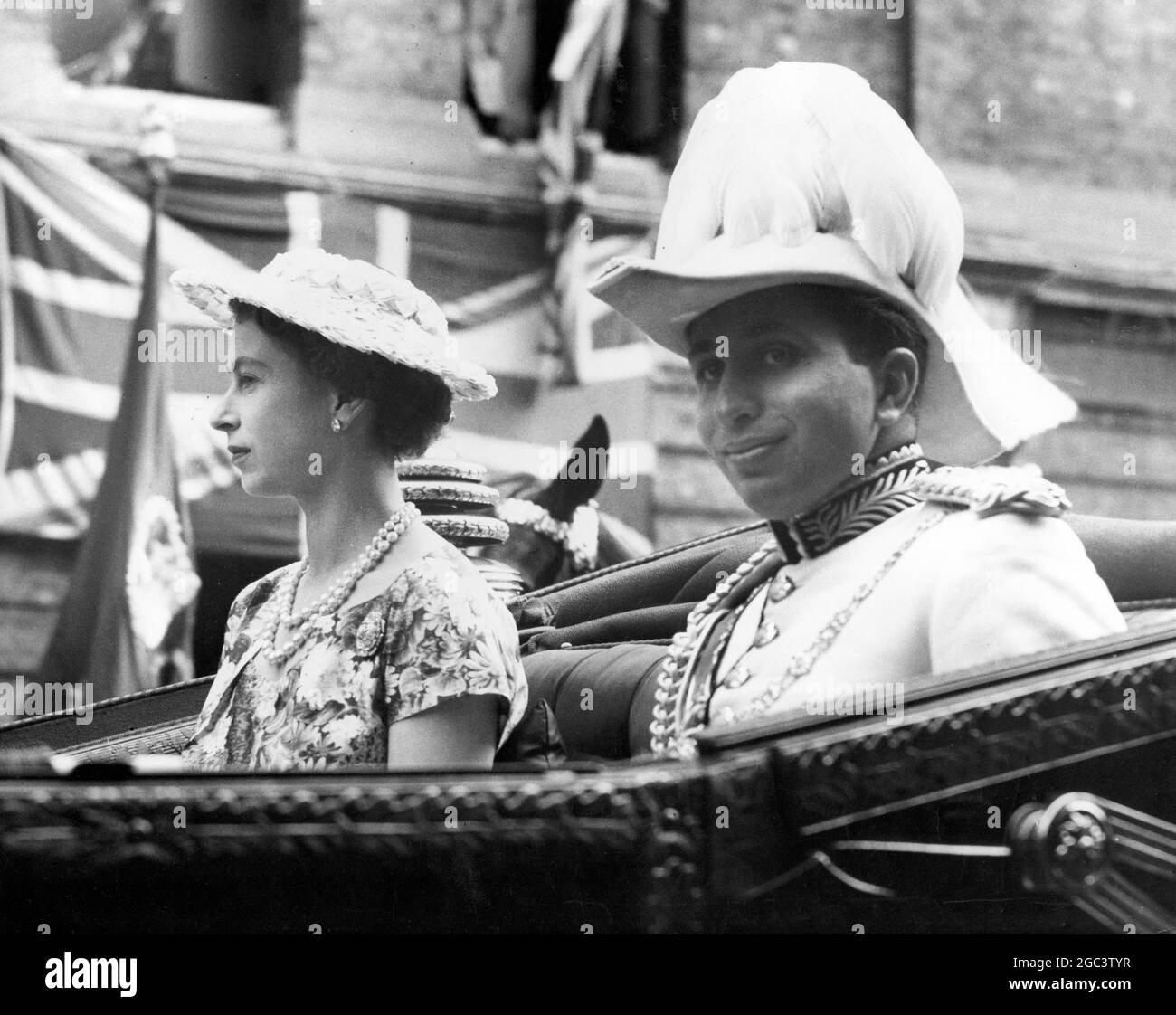 16. Juli 1956 König Faisal II. Von Irak fährt in einem offenen Wagen mit Königin Elizabeth II. Von Victoria Station zum Buckingham Palace, London, für einen Staatsbesuch in England. Es ist der erste Staatsbesuch eines irakischen Monarchen. Stockfoto