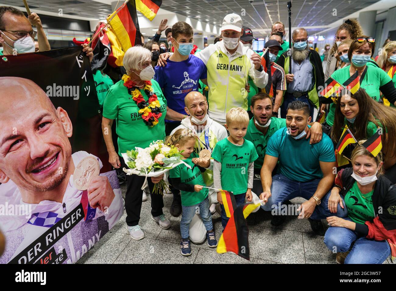 Frankfurt, Deutschland. August 2021. 06. August 2021, Hessen, Frankfurt/Main: Wrestler Frank Stäbler (vorne, 2. V.l.) wird am Abend nach der Rückkehr aus Tokio von zahlreichen Fans, Freunden und Familienmitgliedern am Frankfurter Flughafen begrüßt. Bei den Olympischen Spielen hatte er die Bronzemedaille in der Kategorie unter 67 kg gewonnen. Foto: Frank Rumpenhorst/dpa Quelle: dpa picture Alliance/Alamy Live News Stockfoto