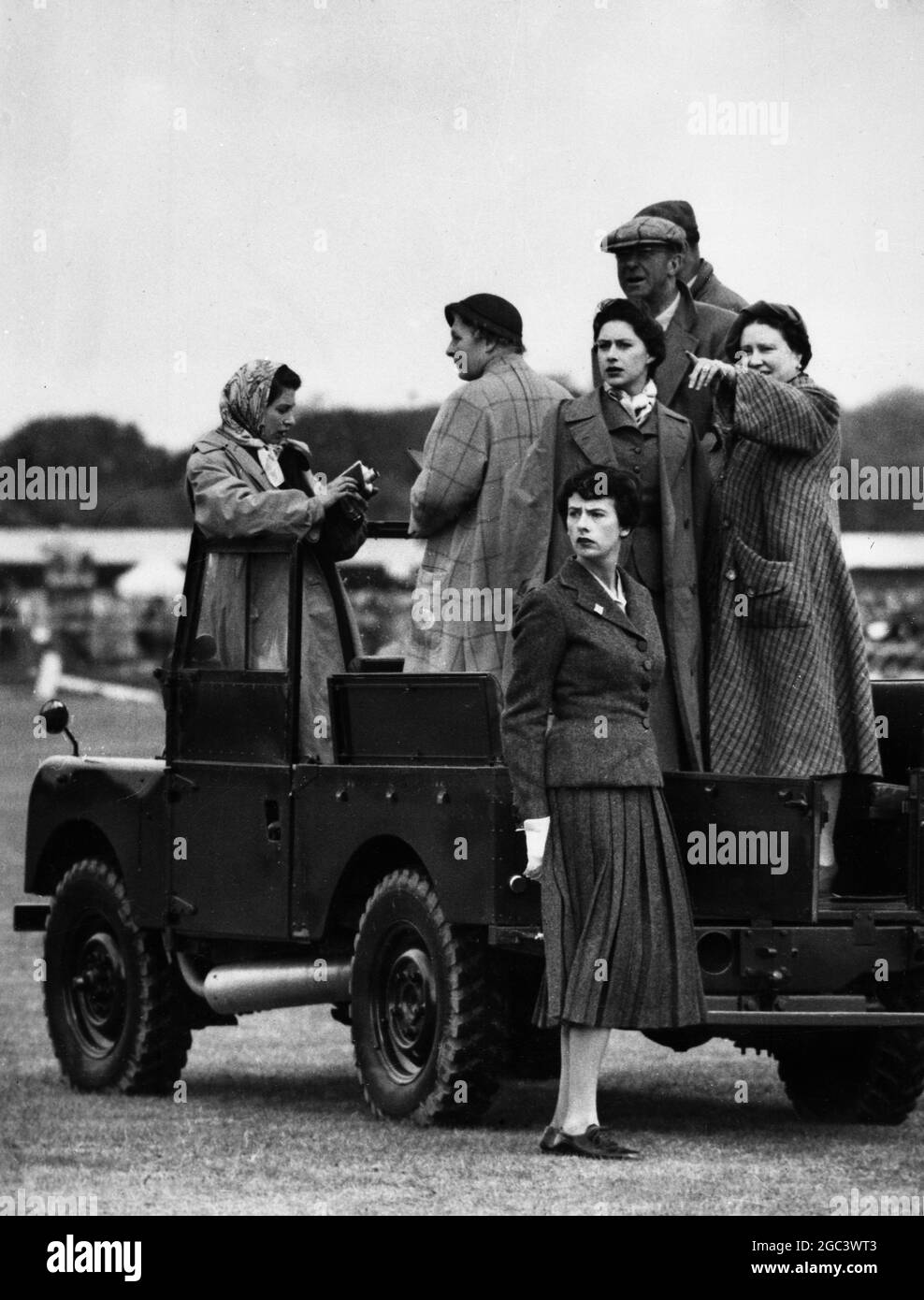 Königin Elizabeth (mit einer Filmkamera); die Königin Mutter, und Prinzessin Margaret, mit Mitgliedern ihrer Partei (nicht identifiziert), beobachten den dritten Tag der Europäischen Pferdetrials von einem Land Rover in Windsor Great Park, angrenzend an die Grenze zu den Bergen von Surrey, England. 20 Mai 1955 Stockfoto
