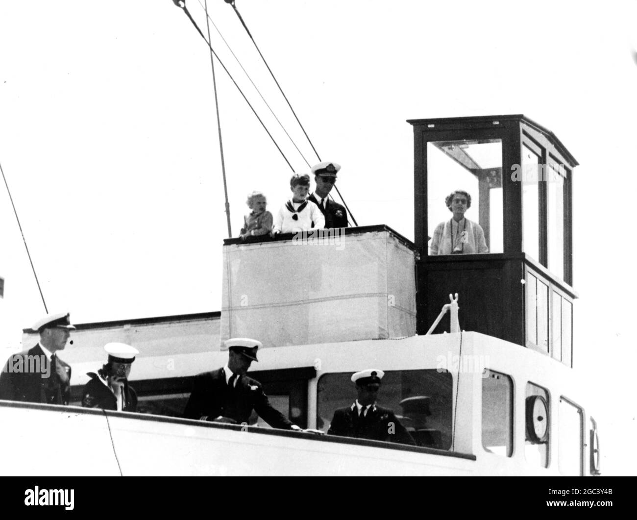 Mitglieder der königlichen Familie beobachten, wie der Oberbefehlshaber, Mediterranean, Admiral, der Earl Mountbatten von Burma KC, während der Reise Ihrer Majestät der Königin von Tobruk nach Malta von Jackstay von seinem Flaggschiff HMS Glasgow nach HMY Britannia verlegt wird. 5 Mai 1954 Stockfoto