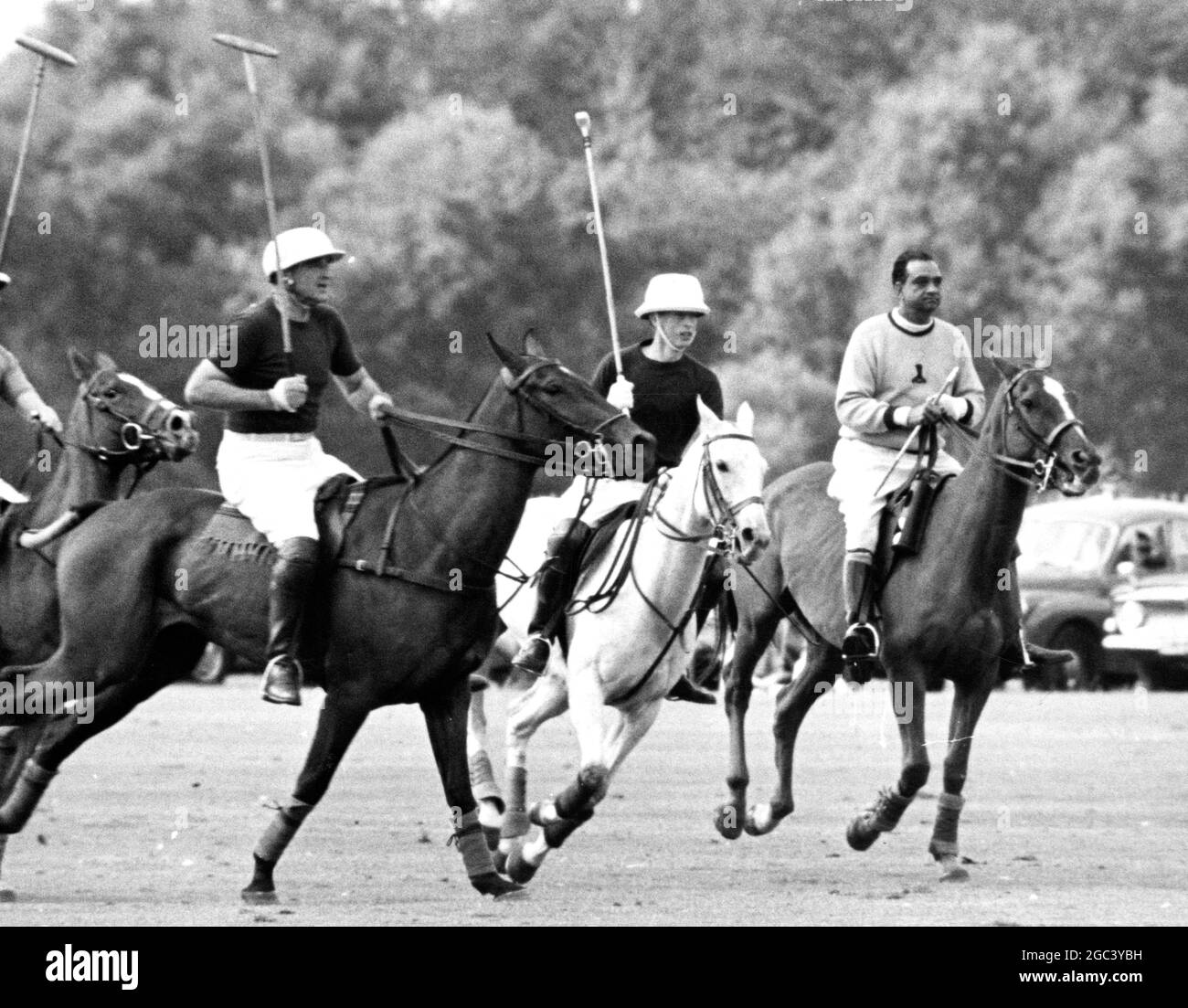 Prinz Charles (Mitte) hält mit dem Spiel in Windsor Schritt, als er für die Rangers gegen Chiesmans im Chairman's Cup auftrat. Sein Vater, der ihn heute Nachmittag beobachtete, konnte wegen eines angespannten Muskels in seinem Oberschenkel nicht an dem dreitägigen Turnier teilnehmen. Auf seiner linken Seite ist J Cavanagh und auf seiner rechten Seite der Maharaja von Jaipur als Schiedsrichter. 7. August 1965 Stockfoto