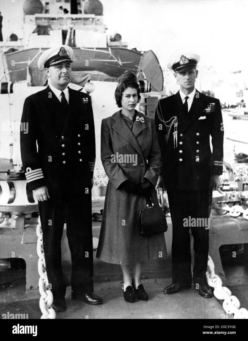 Prinzessin Elizabeth mit dem Herzog von Edinburgh (links) und Capt J. E. H. McBeath (rechts) posiert für ein Gruppenfoto auf HMS Chequers auf Malta während ihres Besuches beim Zerstörer am zweiten Weihnachtsfeiertag. Der Herzog ist Oberleutnant auf den Chequers, die von Malta aus zum Roten Meer segelt. Prinzessin Elizabeth inspizierte die Schiffsgesellschaft am 27. Dezember 1949 Stockfoto