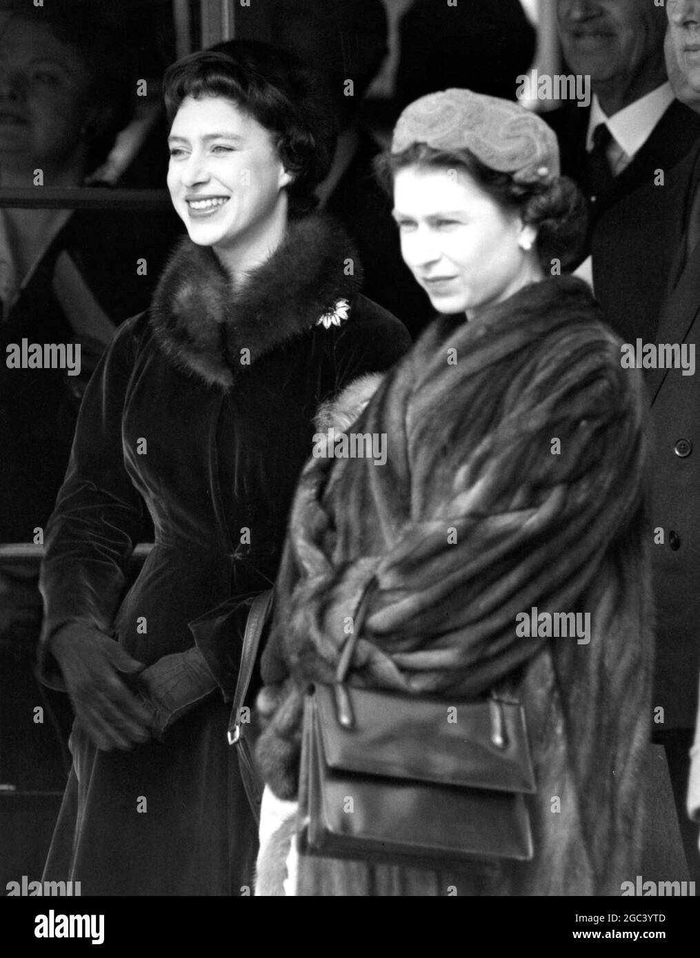 Wir warten darauf, Königin Elizabeth, die Königin Mutter, von ihrer Commonwealth-Tour zu treffen. Foto-Shows: Königliche Sisster warten darauf, ihre Mutter am Londoner Flughafen zu begrüßen. Ihre Königliche Hoheit Prinzessin Margaret, die sich offensichtlich sehr über den Gedanken an die Rückkehr ihrer Mutter aufgeregt hat, steht neben der Königin HM am 13. März 1958 Stockfoto