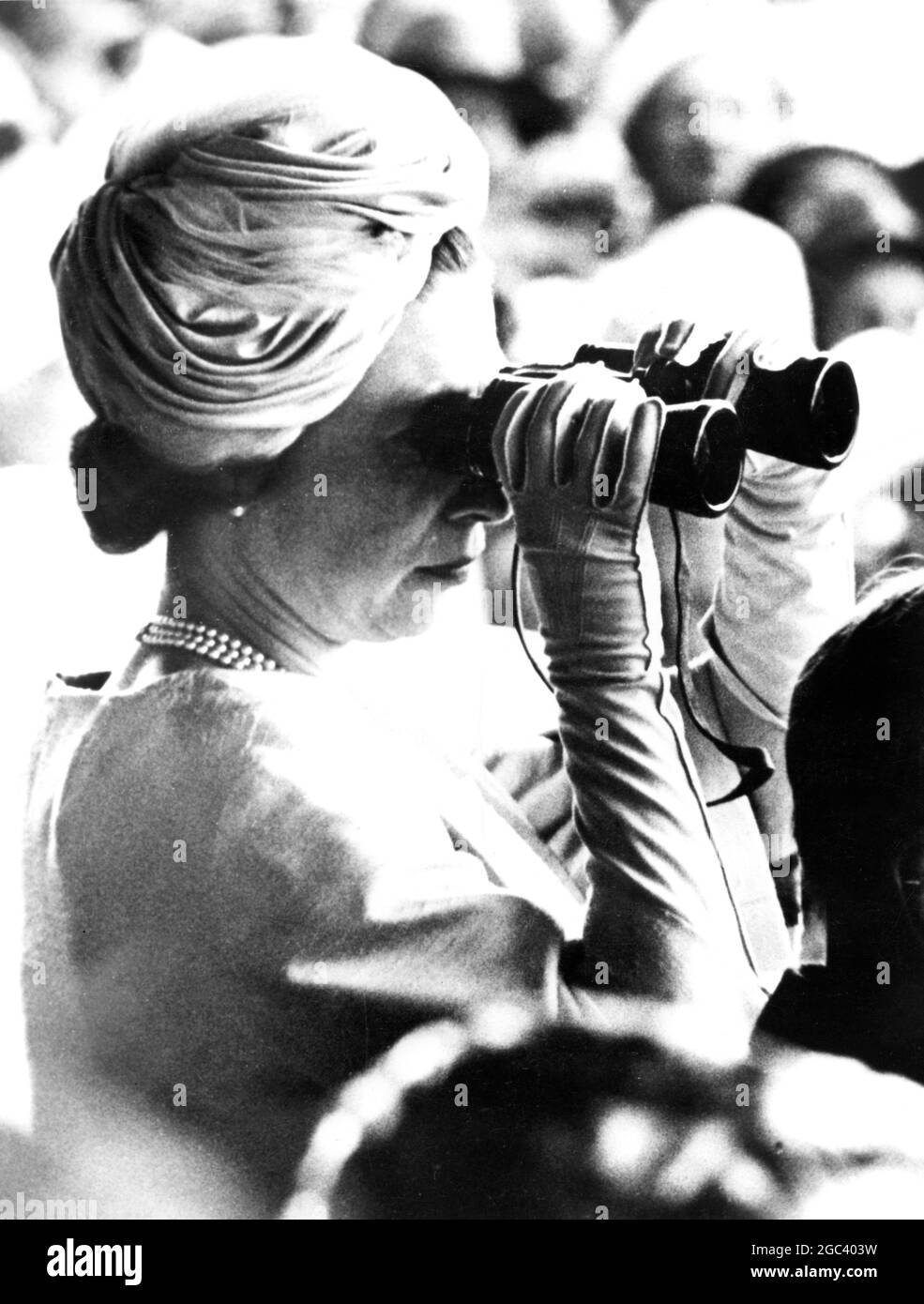 DIE KÖNIGIN IN NEUSEELAND DIE KÖNIGIN schaut durch ein Fernglas auf den Lauf des Queen Elizabeth II Handicap auf der Riccanton Racecourse, Christchurch. 16. Februar 1963 Stockfoto
