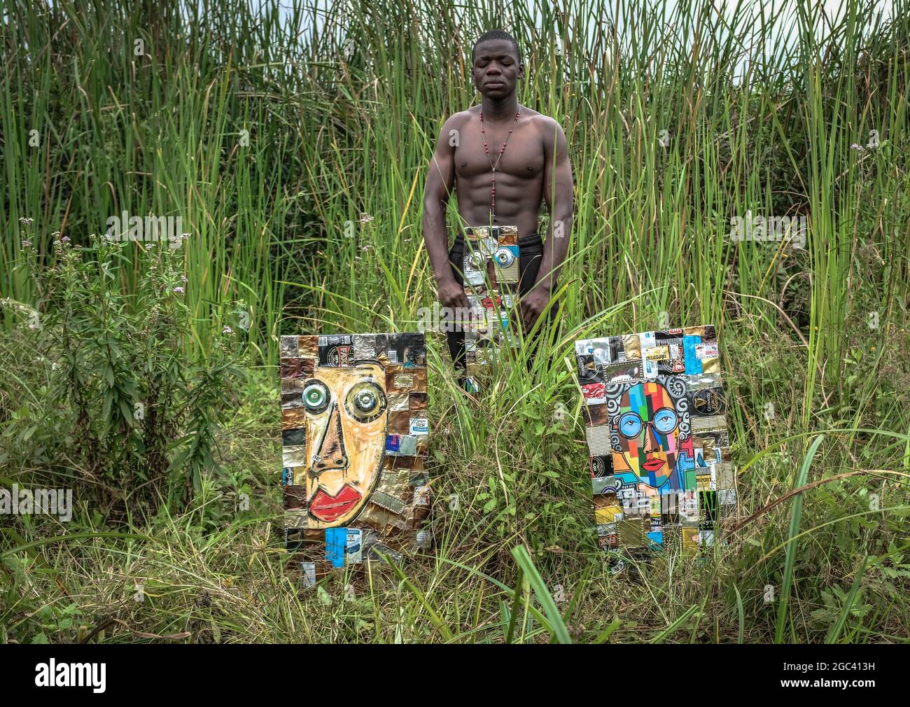 Der 18-jährige Retter Omondi führt seine Einzelausstellung seiner Kunst vor, die er aus recycelten Dosen und alten Eisenblechen, die in den dicken Büschen stehen, herstellt.ein 18-jähriger Künstler, geboren und aufgewachsen in Kibera, aus einer fünfköpfigen Familie, Er begann seine Liebe zur Kunst bereits 2009, indem er die meisten Fähigkeiten von seinem Vater, der Kunst machte, aber nicht auf ein professionelles Niveau, kopierte und erlernte. Omondis Hauptaugenmerk lag auf der Darstellung seiner Heimat durch seine Kunstwerke und dem Traum, nach seinem Studium das Beste aus seiner Kunst herauszuholen. Stockfoto