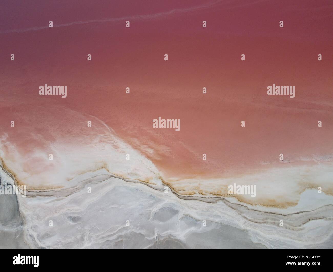 Luftaufnahme oben unten breiten Schuss rosa Salzsee. Fliegen über die rosa gefärbten Lagunen von Salzfeldern. Malerische Drohne Blick auf das bunte Salz Stockfoto
