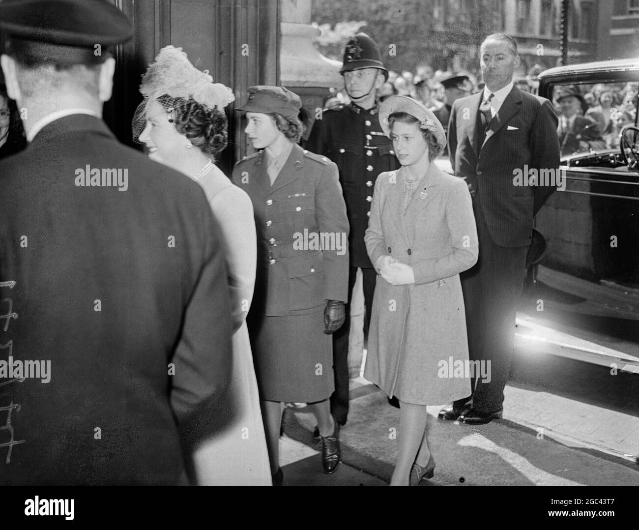 König Georg VI. UND KÖNIGIN Elisabeth, begleitet von den beiden Prinzessinnen, Prinzessin Elizabeth in Uniform und Prinzessin Margaret, die am Parlamentsgebäude ankommt. 17 Mai 1945 Stockfoto