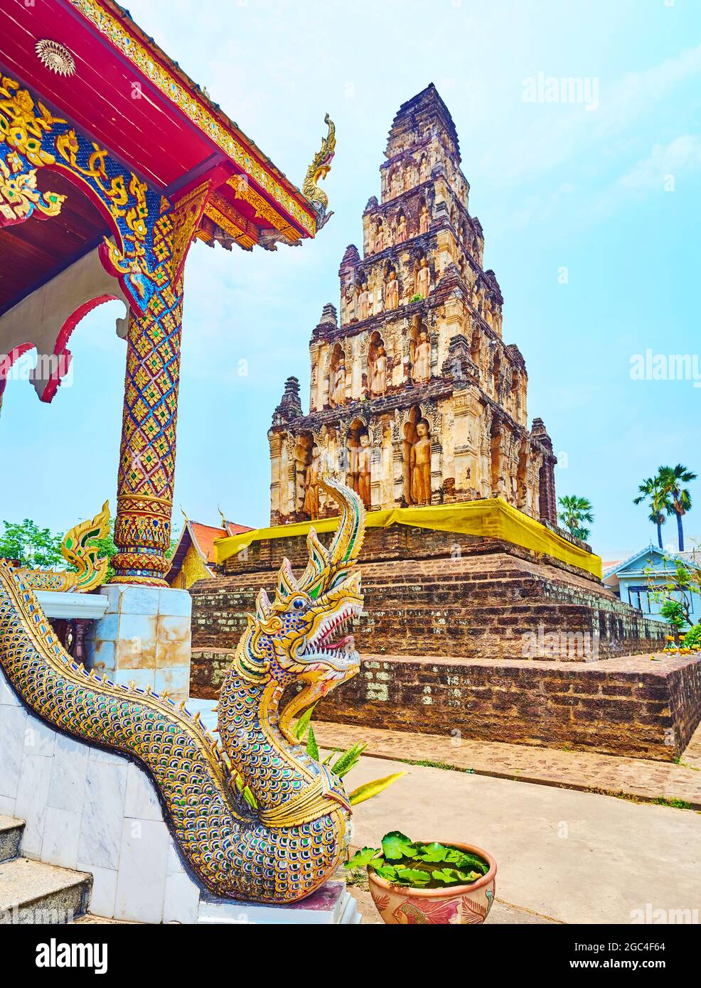 Die szenische Skulptur der Naga-Schlange, die den Viharn des Wat Chammathewi-Tempels vor dem alten Suwan Chedi Jungkote Stupa, Lamphun, Thail bewacht Stockfoto