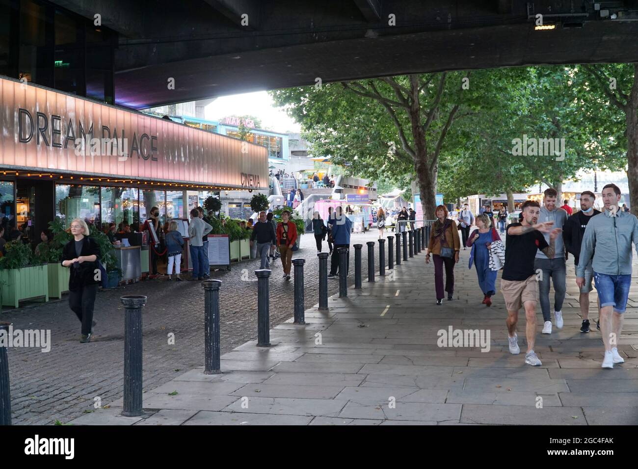 London, Großbritannien, 6. August 2021: Am Freitagseveining am Londoner South Bank werden die Massen von einer Reihe von Veranstaltungen im Freien begrüßt und Theater und Kino werden im National Theatre und BFI wieder aufgenommen. Eine Bühne im Freien mit DJ-Sets lädt Trinker und Tänzer zum Genießen ein, und Gäste nehmen Tische im Freien ein, wenn sich der Regen für einen sonnigen Sommerabend klärt. Einige Leute tragen Masken im Freien, aber die meisten tragen sie nur im Innenbereich oder in öffentlichen Verkehrsmitteln. Anna Watson/Alamy Live News Stockfoto