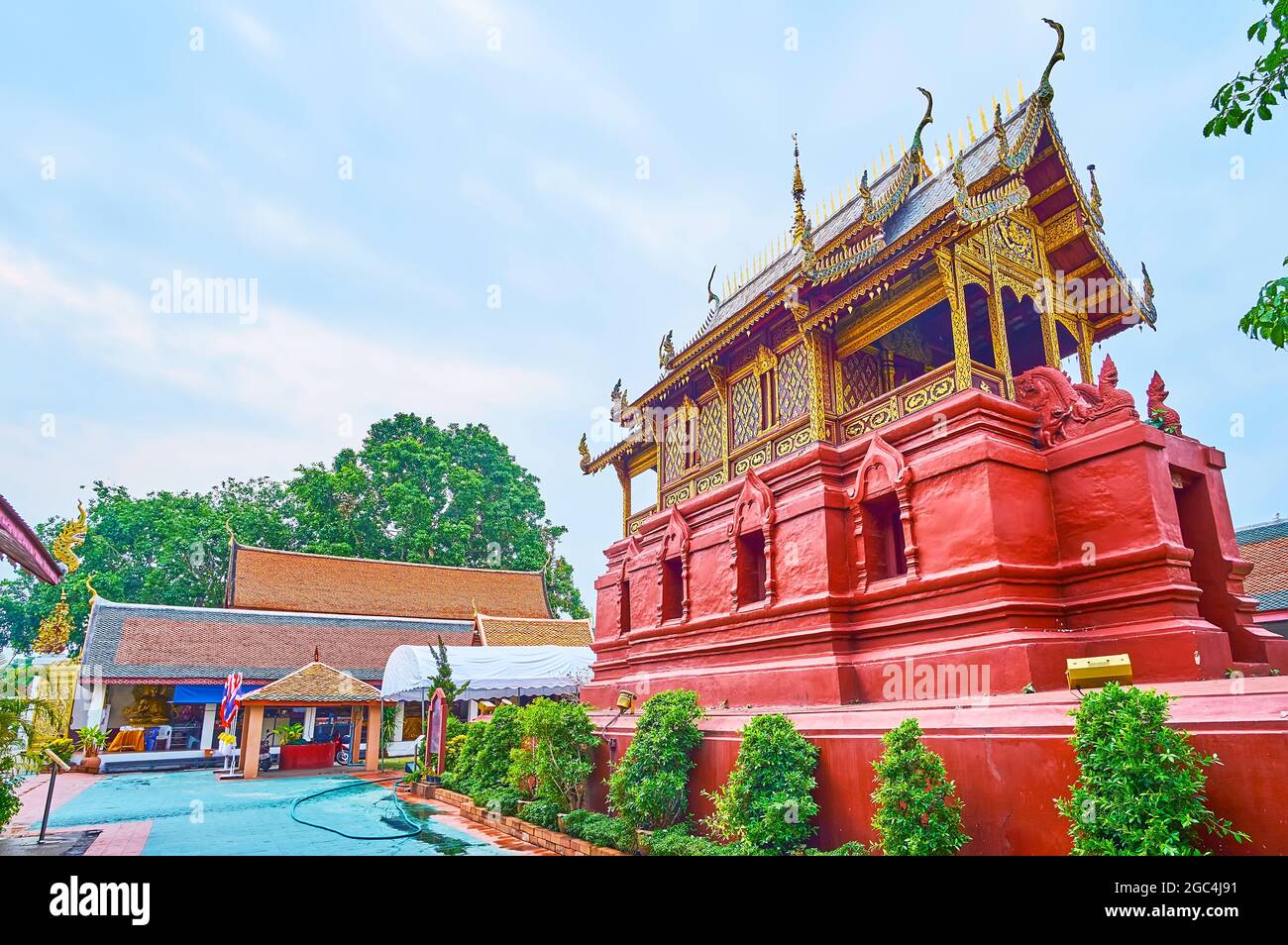 Die malerische rote Ho Trai Buddhistische Bibliothek, die heilige Manuskripte enthält, Wat Phra That Hariphunchai Tempel, Lamphun, Thailand Stockfoto