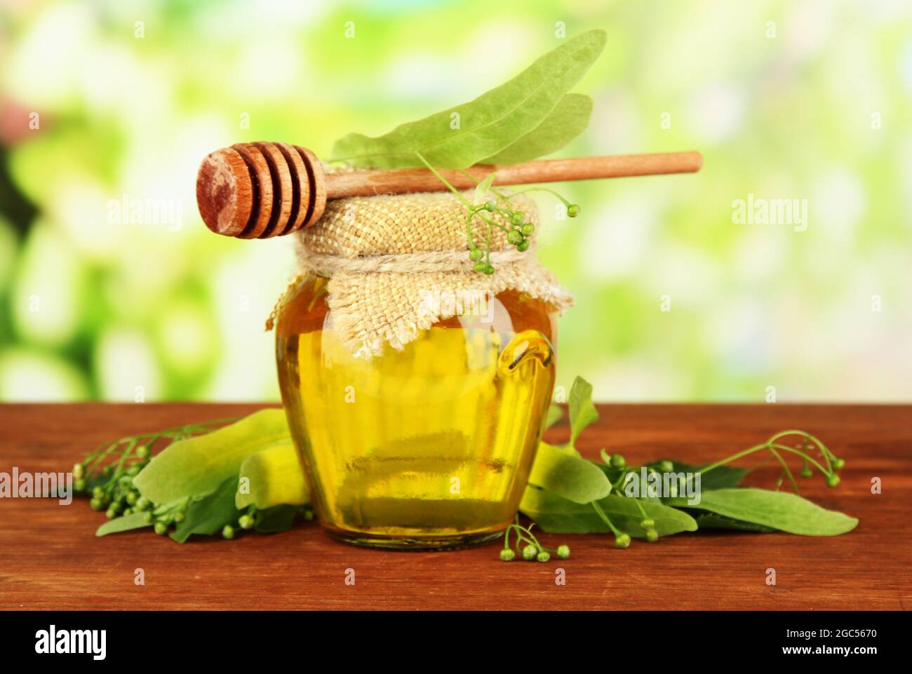 Krug Honig mit Blumen von Kalk, auf Holztisch auf hellen Hintergrund  Stockfotografie - Alamy