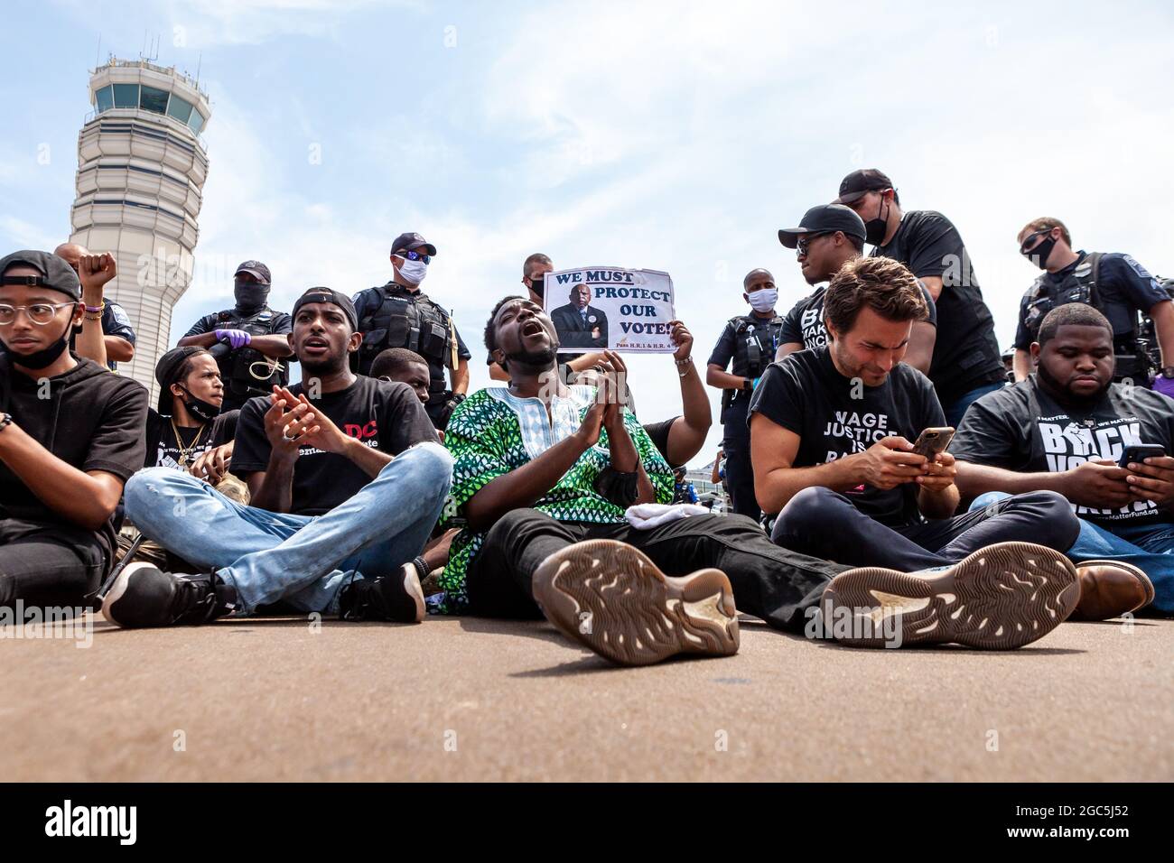 Washington DC, USA, 6. August 2021. Im Bild: Reverend Stephen Green (Mitte) führt während eines Freitagsmarsches Demonstranten an, die den Verkehr am Reagan National Airport blockieren. Die Demonstranten wollten Senatoren daran hindern, in die Pause zu gehen, weil sie noch nicht zum Schutz der Stimmrechte gehandelt hatten. Bei dieser zivilen Ungehorsams-Aktion wurden etwa 25 Demonstranten verhaftet. Kredit: Allison Bailey / Alamy Live Nachrichten Stockfoto