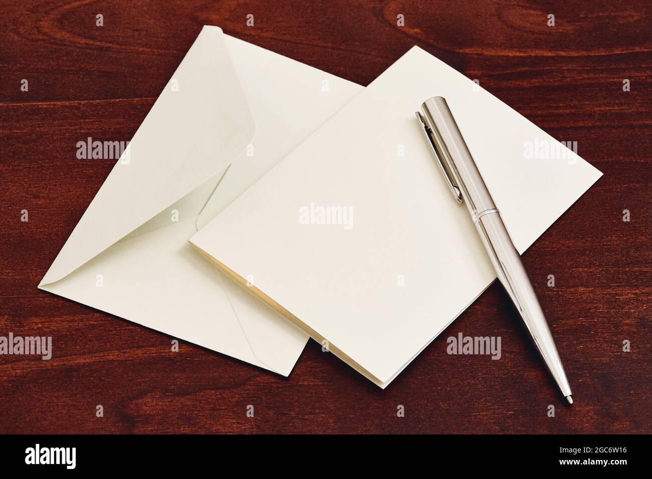 Umschlag und Stift auf Holztisch Stockfoto