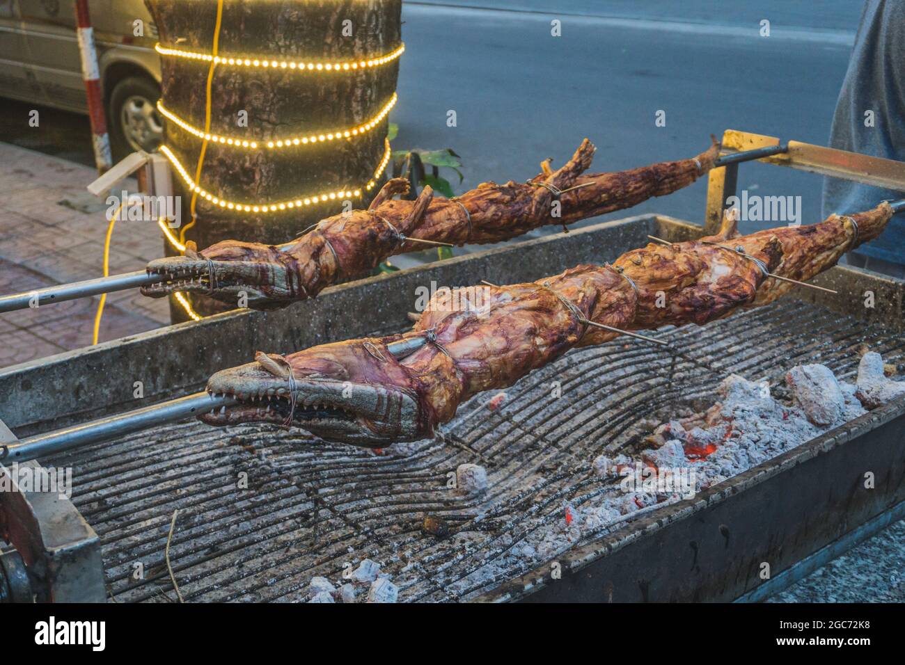 Gegrilltes Krokodil am offenen Feuer im Sea Food Restaurant, exotische Mahlzeiten in Vietnam, Speisen der asiatischen Küche, rohes Krokodilfleisch, exotische Speisen. Stockfoto