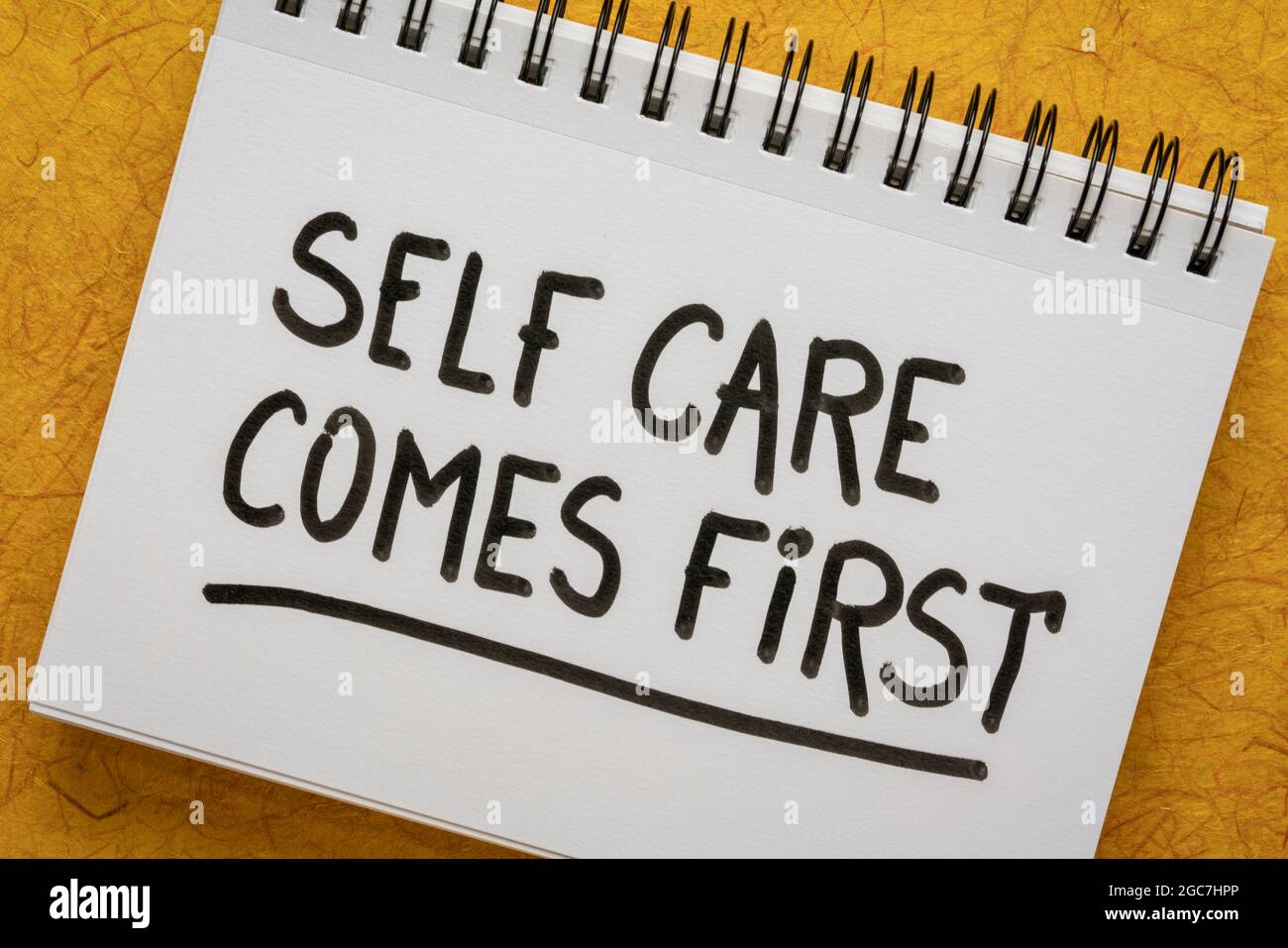 Self Care kommt zuerst inspirierende Erinnerung - Handschrift in einem Skizzenbuch, Körper positiv, psychische Gesundheit Slogan Stockfoto