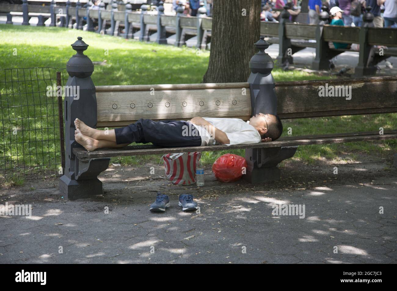 An einem warmen Sommertag im Central Park, New York City, macht der Mann einen Schlummer. Stockfoto