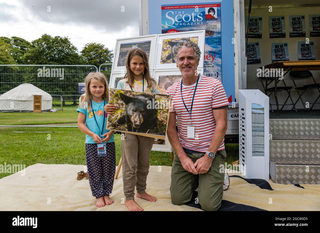 North Berwick, East Lothian, Schottland, Großbritannien, 7. August 2021. Gordon Buchanan in Fringe-by-the-Sea: Gordon Buchanan, bekannter Naturfotograf und Filmemacher der TV-Serie „Family & Me“, signiert Kopien seiner Wildtierfotos, hier mit Aila Reid, 5 Jahre alt, und Etta Reid, 8 Jahre alt, und einem seiner Bärenfotos Stockfoto