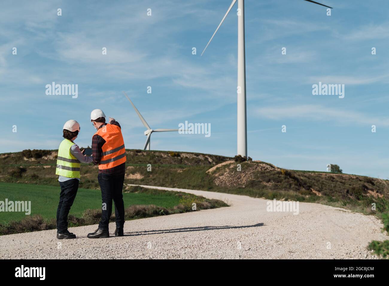 Ingenieure mit Tablet in Windpark mit alternativer Energie tragen Sicherheitsmasken - Innovation und Green Power Konzept Stockfoto