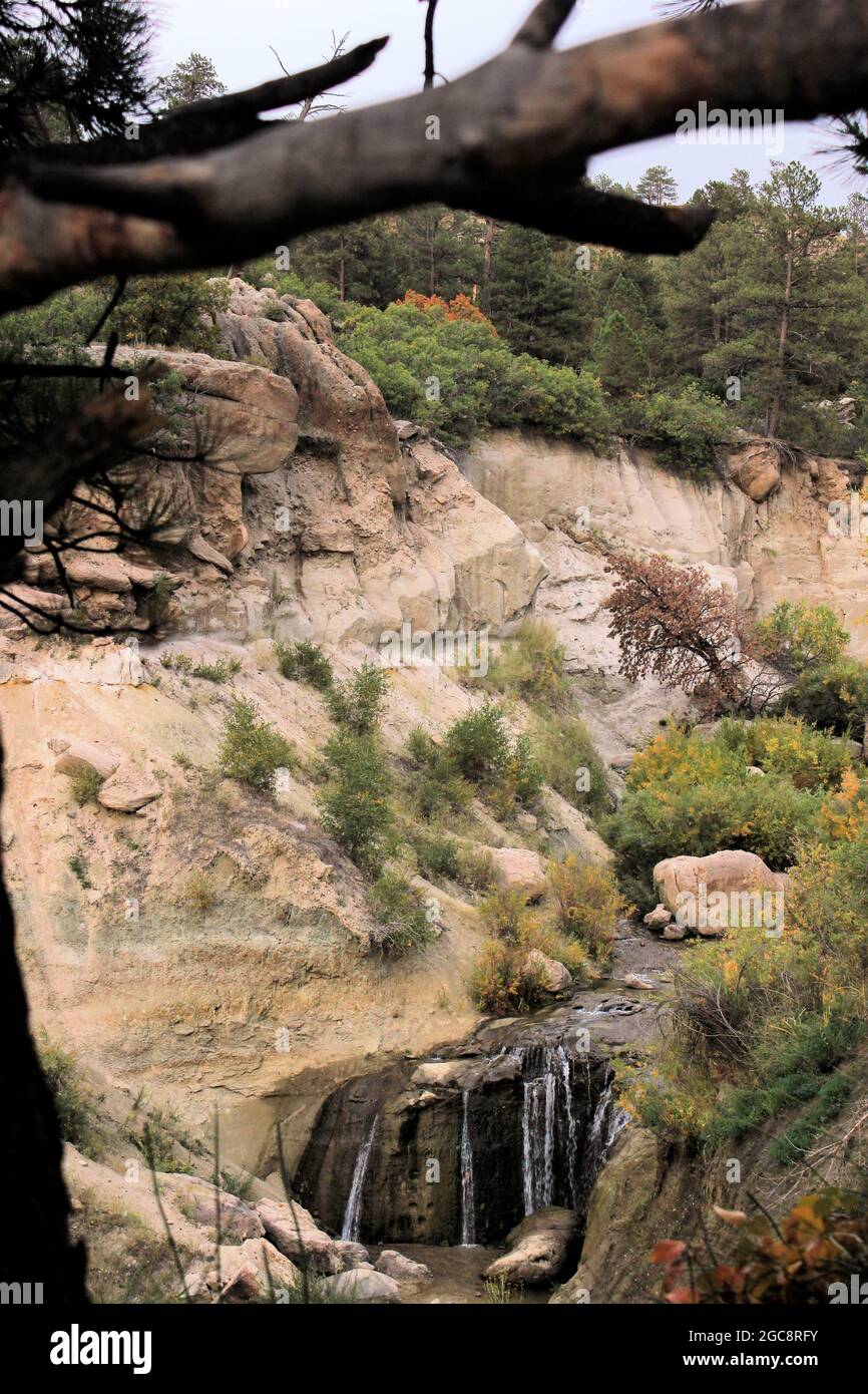 Eine kleine Schlucht mit Flusslauf und einer beruhigenden Wirkung, die durch die Felsen und unter einem umgestürzten Baum fließt Stockfoto