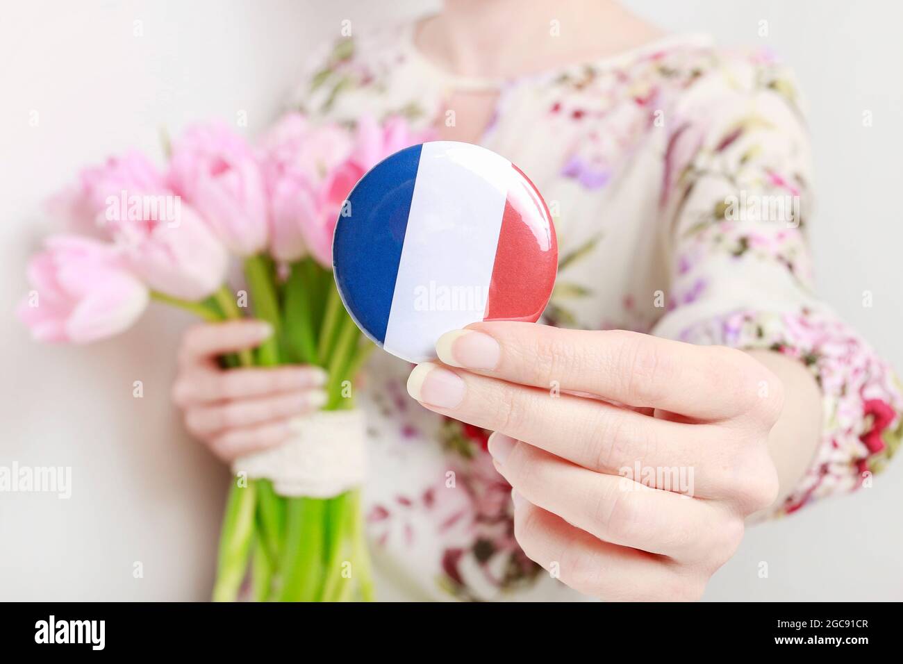 Flagge von Frankreich auf Knopf Abzeichen gedruckt, hält von Frau in ihren schönen Händen. Stockfoto