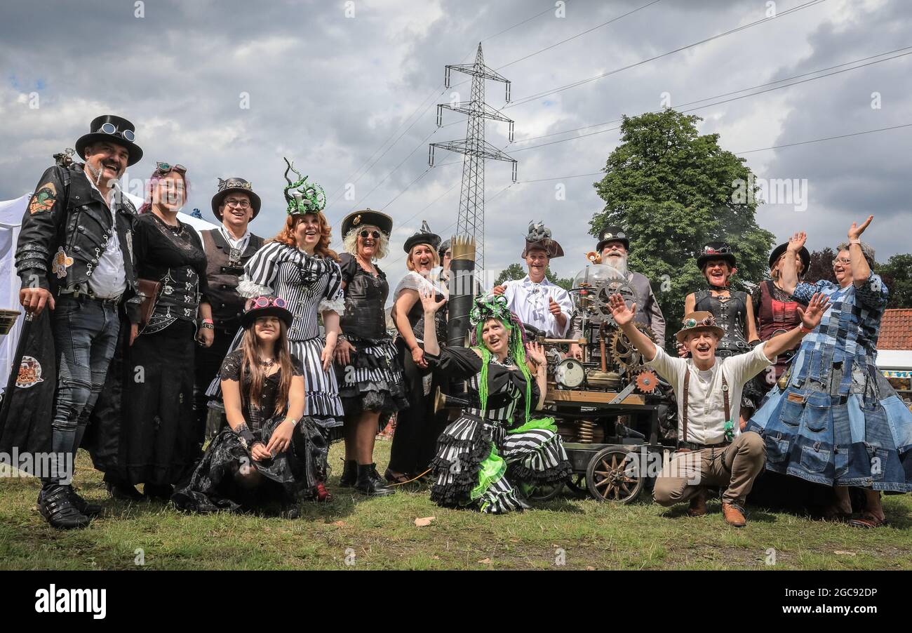 Schiffshebewerk Henrichenburg, Waltrop, Deutschland, 7. August 2021. Die Teilnehmer posieren zusammen mit Mitgliedern des Steampunk ´Stammtisch´für eine Gruppenaufnahme. Steampunk-Fans und Besucher, viele in voll retro-futuristischen Kostümen und Steampunk-Outfits, treffen sich zum ´Steampunk Jubilee Market´ Festival am historischen Wahrzeichen der Henrichenburg-Seilbahn, Teil des Waltrop-Schlossparks am Dortmund-Ems-Kanal, heute ein Industriemuseum. Das alte Eisengerüst, die Kontrolltürme, Maschinenhäuser und das Museum bilden eine stimmungsvolle Kulisse für das Festival Stockfoto