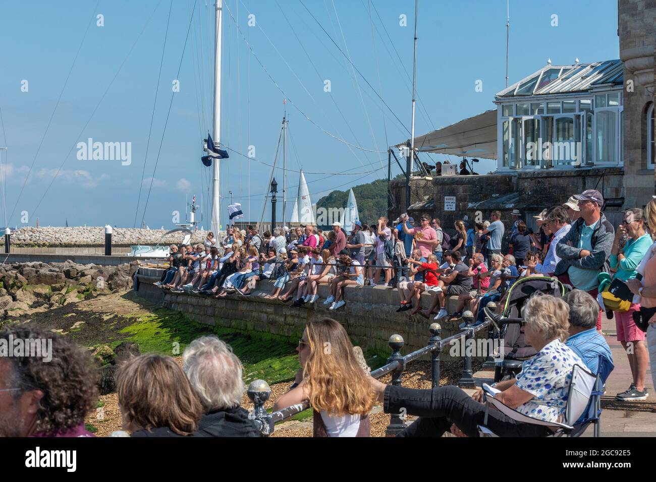 Menschenmassen säumen das Vorland vor dem Royal Yacht Squadraon, um das Yachtrennen während der Cowes Week 2021 auf der Isle of Wight, England, zu beobachten Stockfoto