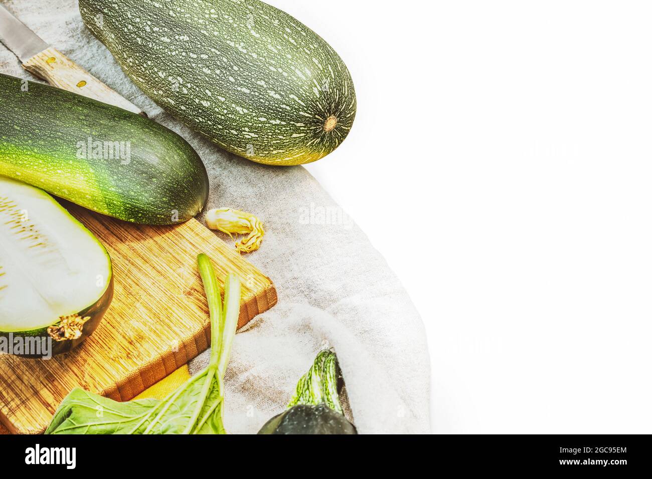 Umweltfreundliche, sommerliche Komposition mit organischen, grünen Zucchini auf weißem Hintergrund mit Platz für Text. Klimafreundliches Essen. Lokal angebaut, Bauernhof ve Stockfoto