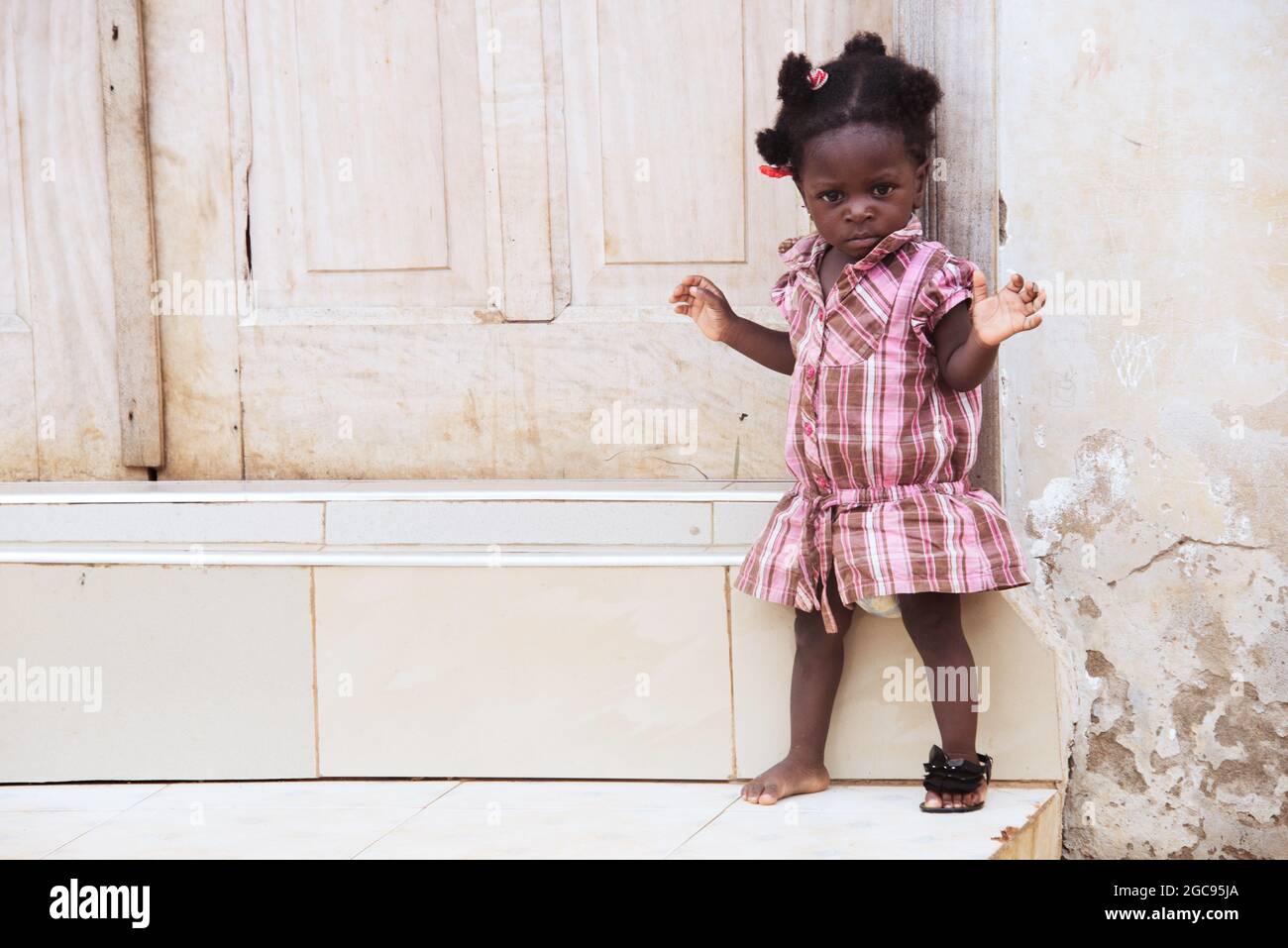 Bezauberndes ghanaische Mädchen mit einem fehlenden Schuh Stockfoto