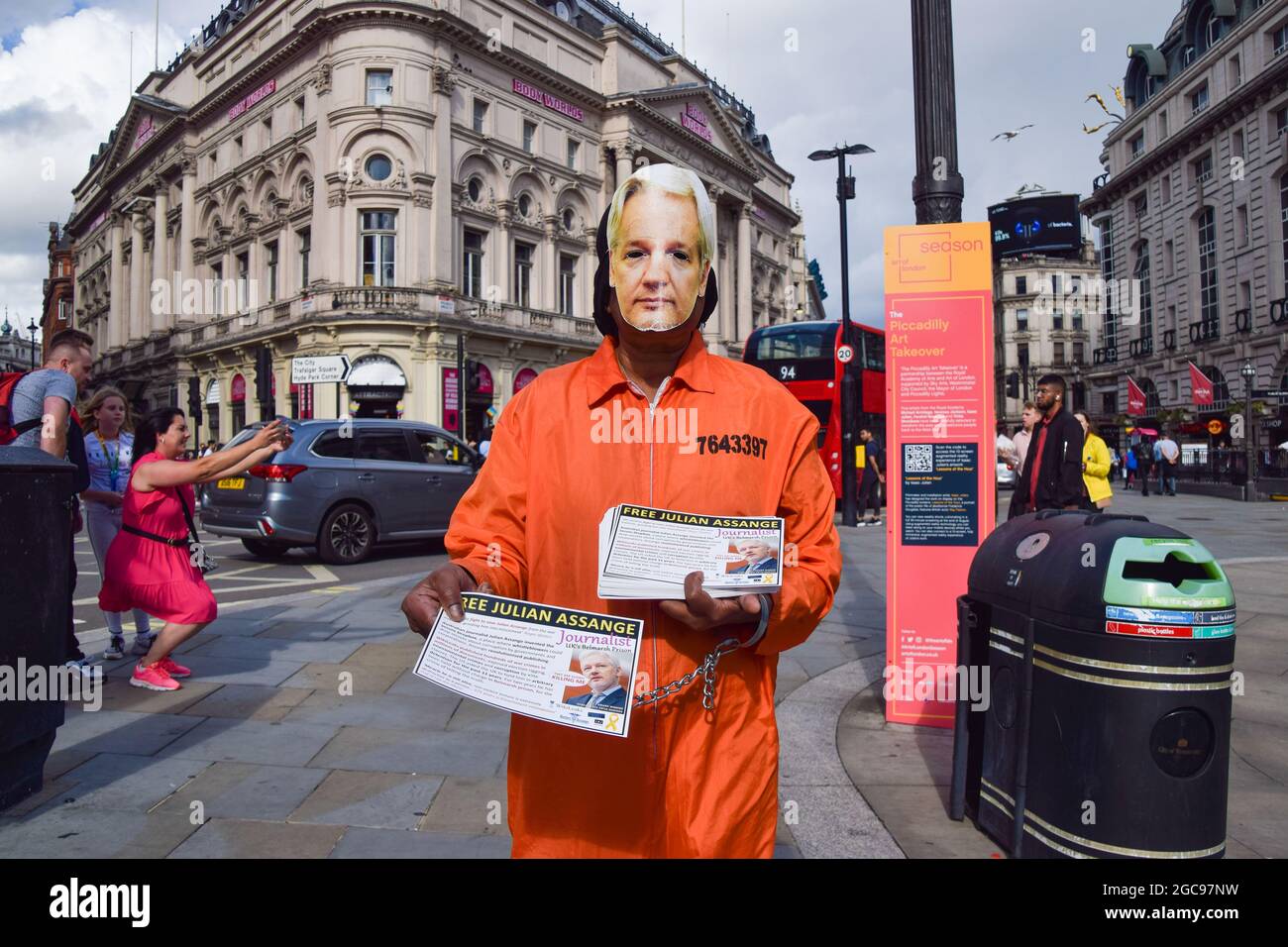 London, Großbritannien. August 2021. Ein Demonstrant, der Gefängniskleidung und eine Assange-Maske trägt, verteilt während der Freien Julian Assange-Proteste im Piccadilly Circus Flugblätter. Im Rahmen der anhaltenden Proteste, die die Freilassung des WikiLeaks-Gründers forderten, versammelten sich erneut Demonstranten. (Kredit: Vuk Valcic / Alamy Live News) Stockfoto