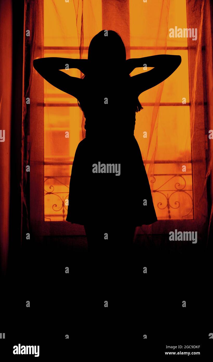 Silhouette einer Frau im Innenbereich, die ein Kleid trägt Stockfoto